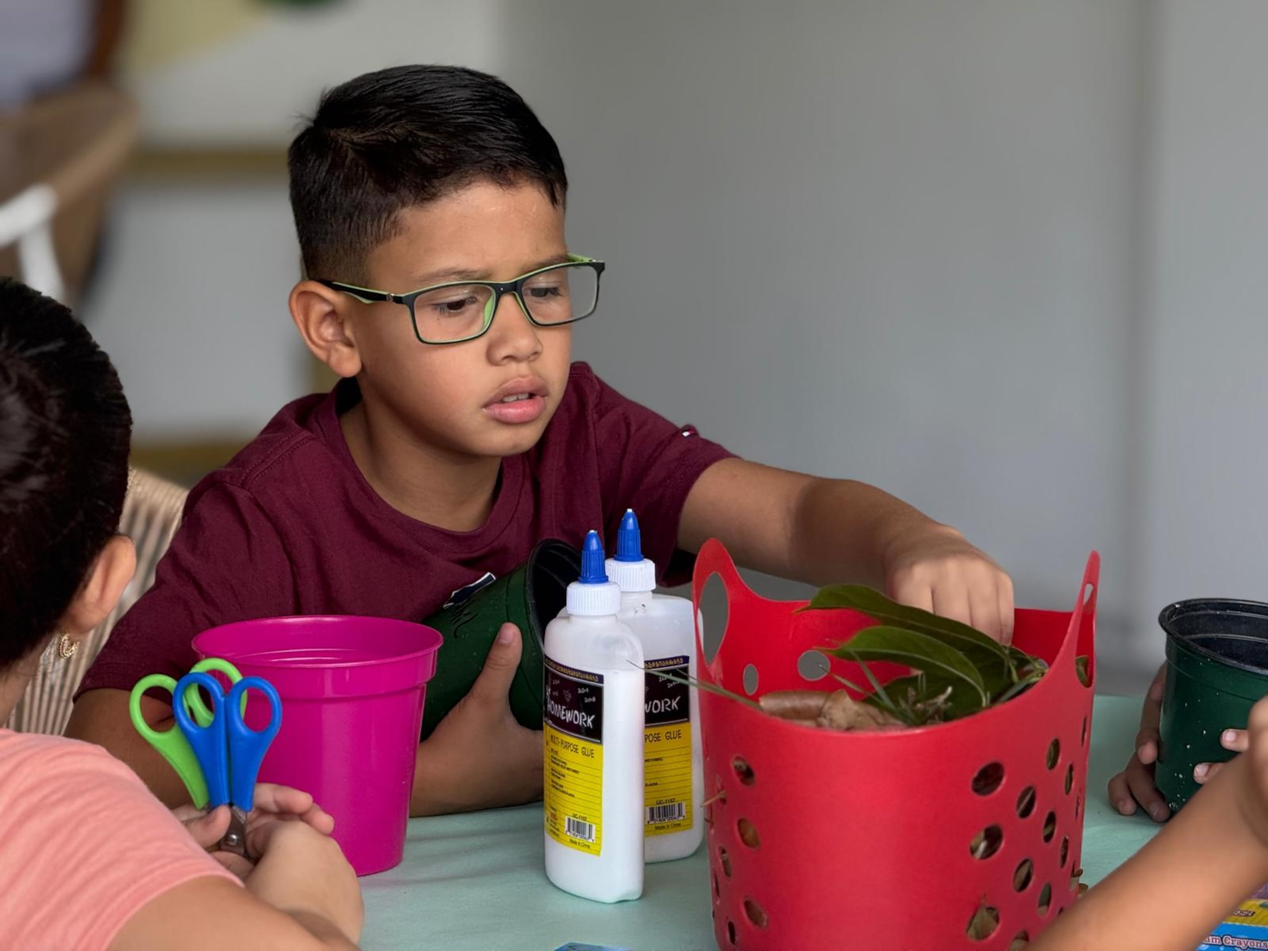 Un niño busca entre los pedazos de la naturaleza recolectado el material para hacer su obra de arte.