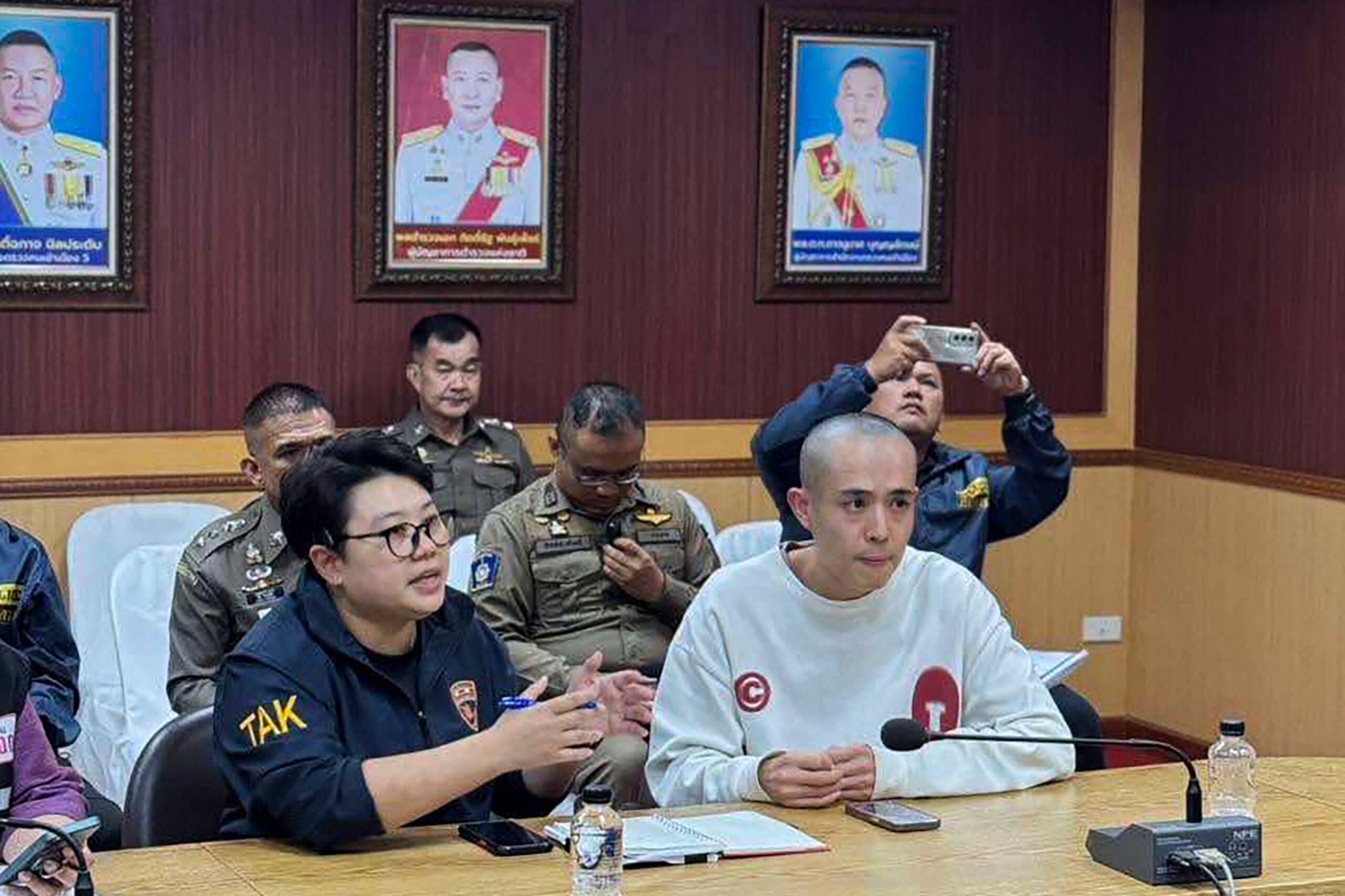 In this image provided by the Royal Thai Police, Chinese actor Wang Xing, right, talks with Thai police officers in Mae Sot district, in Thai-Myanmar border, Tak province Tuesday, Jan. 7, 2025. (The Royal Thai Police via AP)