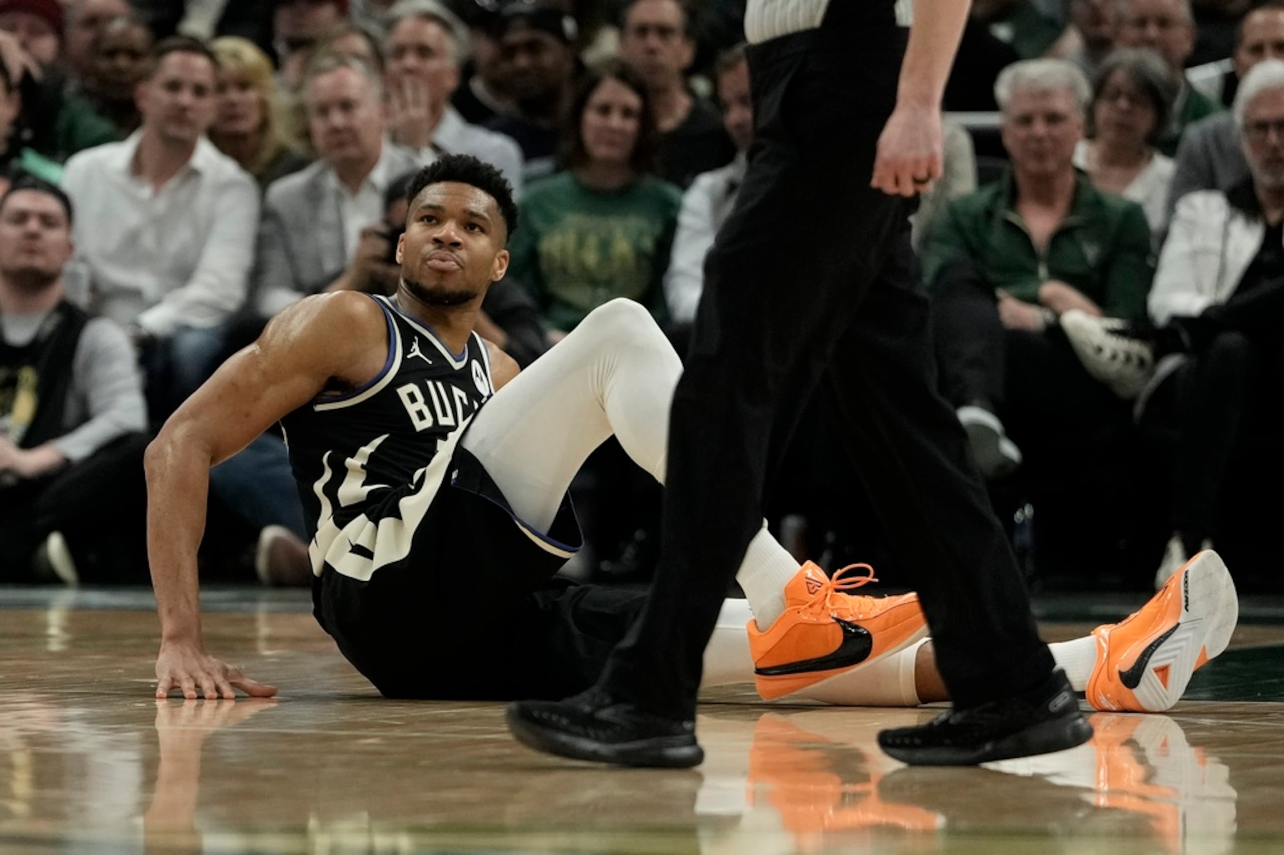 Giannis Antetokounmpo, de los Bucks de Milwaukee, se sienta en la cancha durante el partido ante los Celtics de Boston.