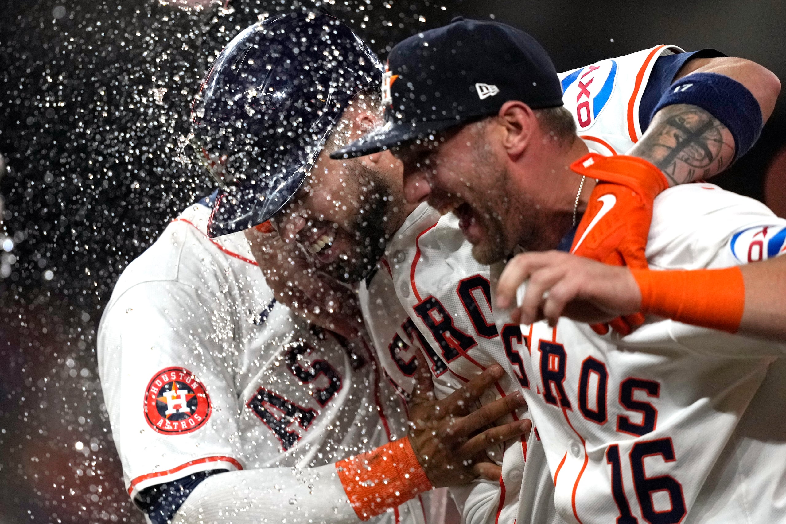 El puertorriqueño Víctor Caratini (centro) festeja con Grae Kessinger (16) y con el dominicano Jeremy Peña, sus compañeros en los Astros de Houston, tras la victoria sobre los Athletics de Oakland.
