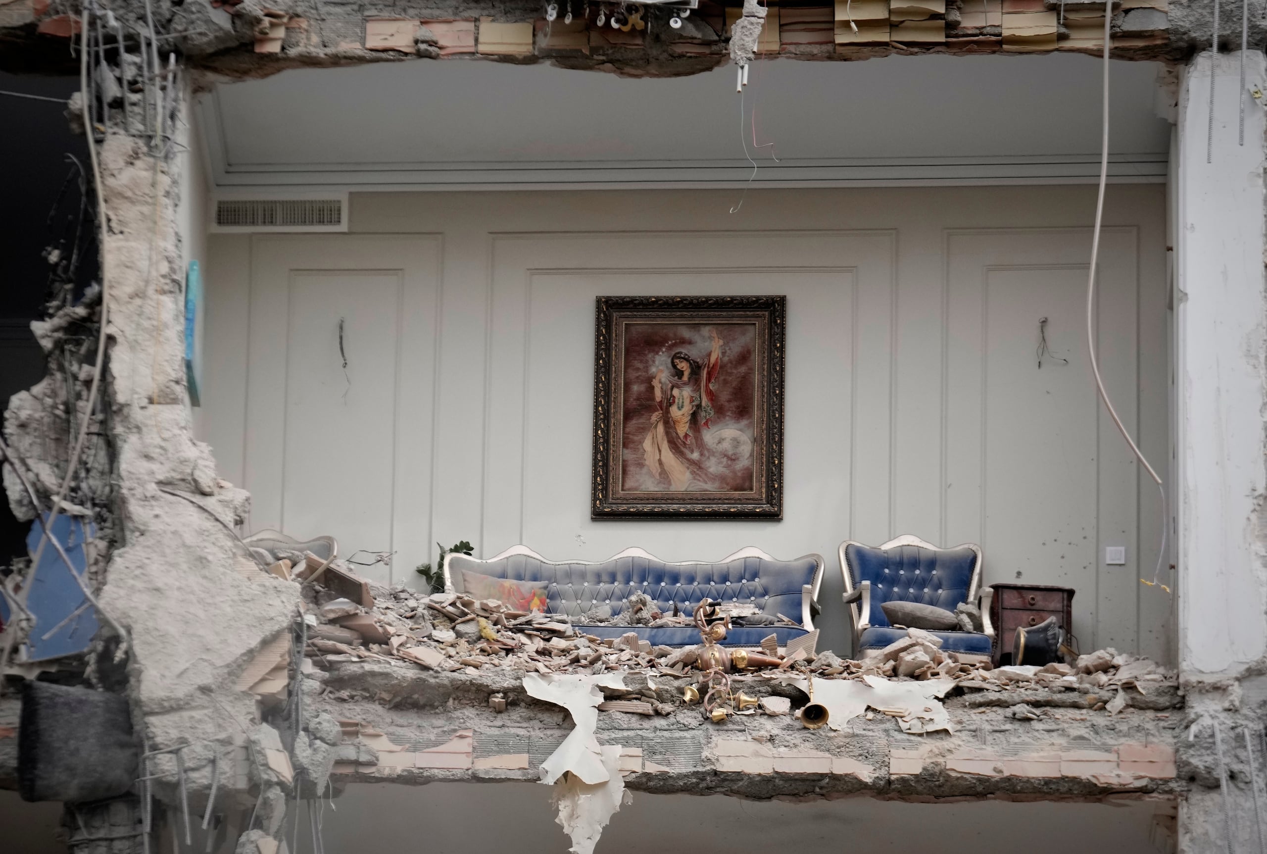 Escombros cubren los muebles de un salón destruido en un edificio residencial golpeado por un ataque anterior de la campaña militar de Estados Unidos e Israel, en Teherán, Irán, el lunes 23 de marzo de 2026. (AP Foto/Vahid Salemi)