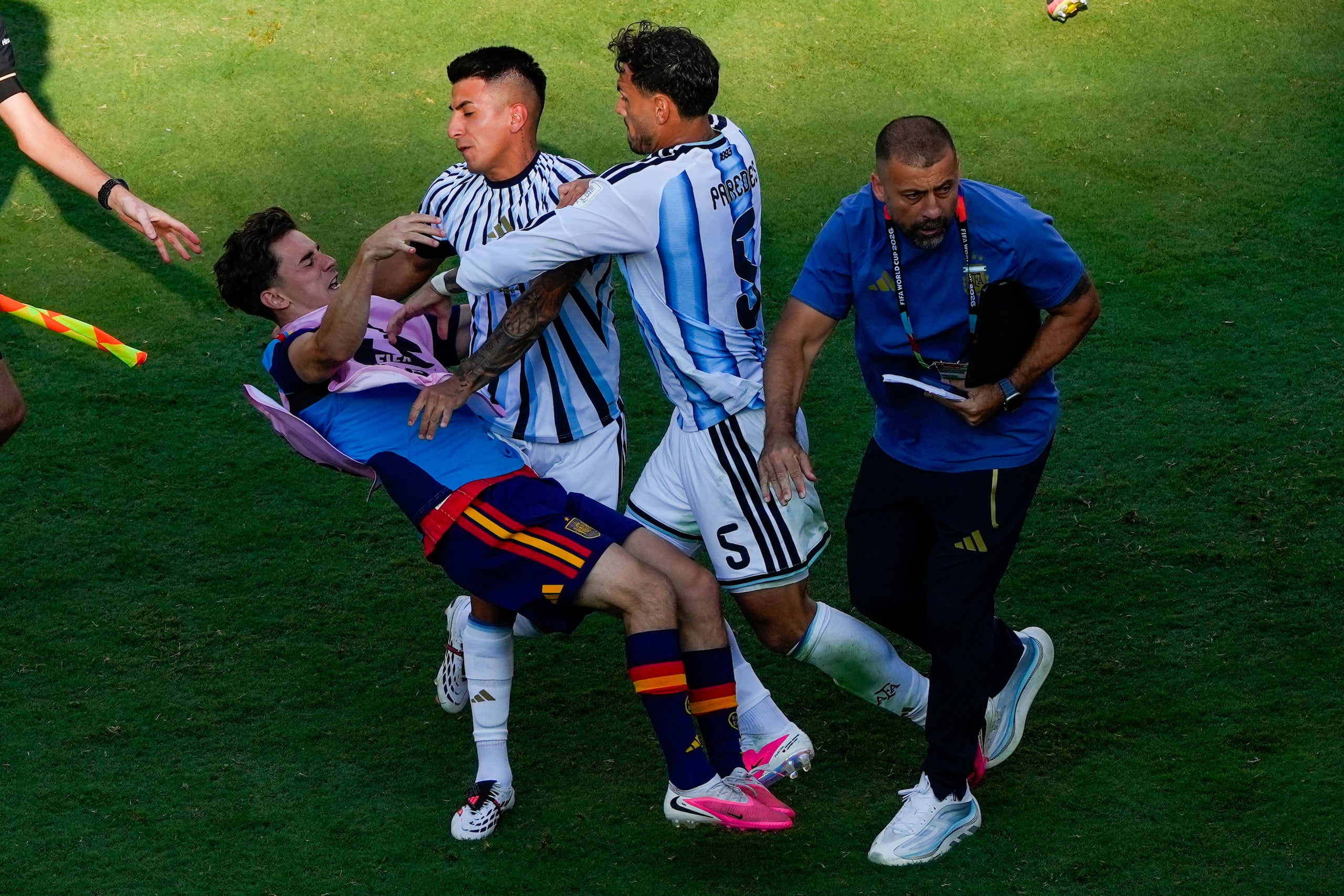 El jugador español Gavi, a la izquierda, es empujado en un choque con el jugador argentino Leandro Paredes (5) y Thiago Almada tras la final del Mundial.