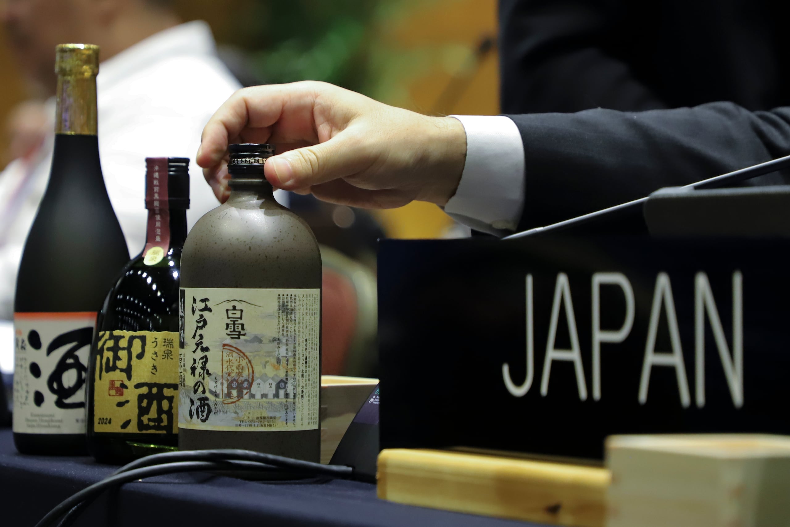 Sake japonés, uno de los candidatos a recibir la designación de Patrimonio Cultural Inmaterial de la Humanidad en exhibición en la mesa de la delegación japonesa, durante la Convención del Patrimonio Mundial de la UNESCO, el miércoles 4 de diciembre de 2024, en Asunción. (AP Foto/Marta Escurra)