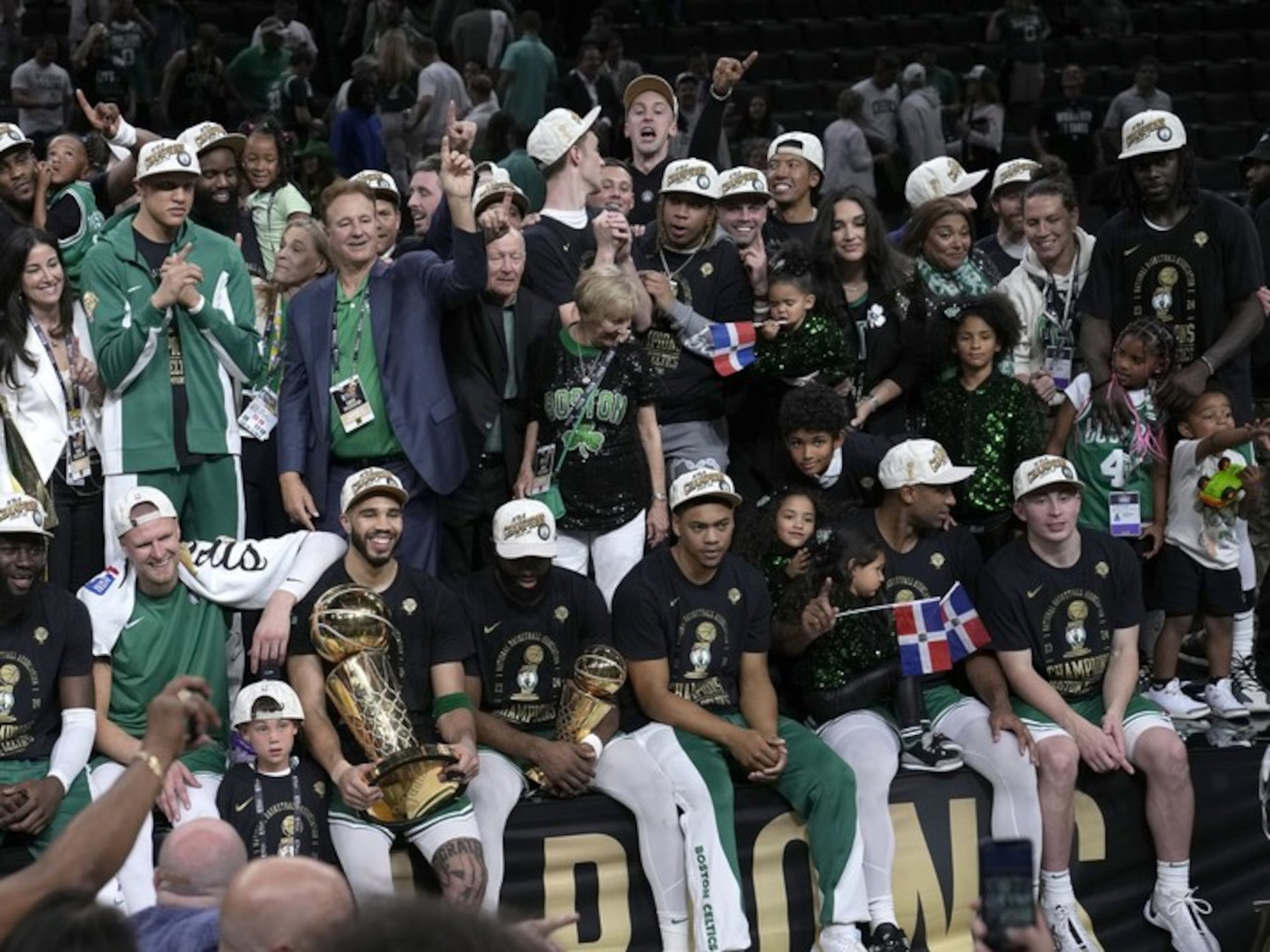 Amelia Vega y Al Horford junto a sus hijos, quienes sostenían banderas de República Dominicana tras el triunfo de los Celtics de Boston ante los Mavericks de Dallas el lunes.