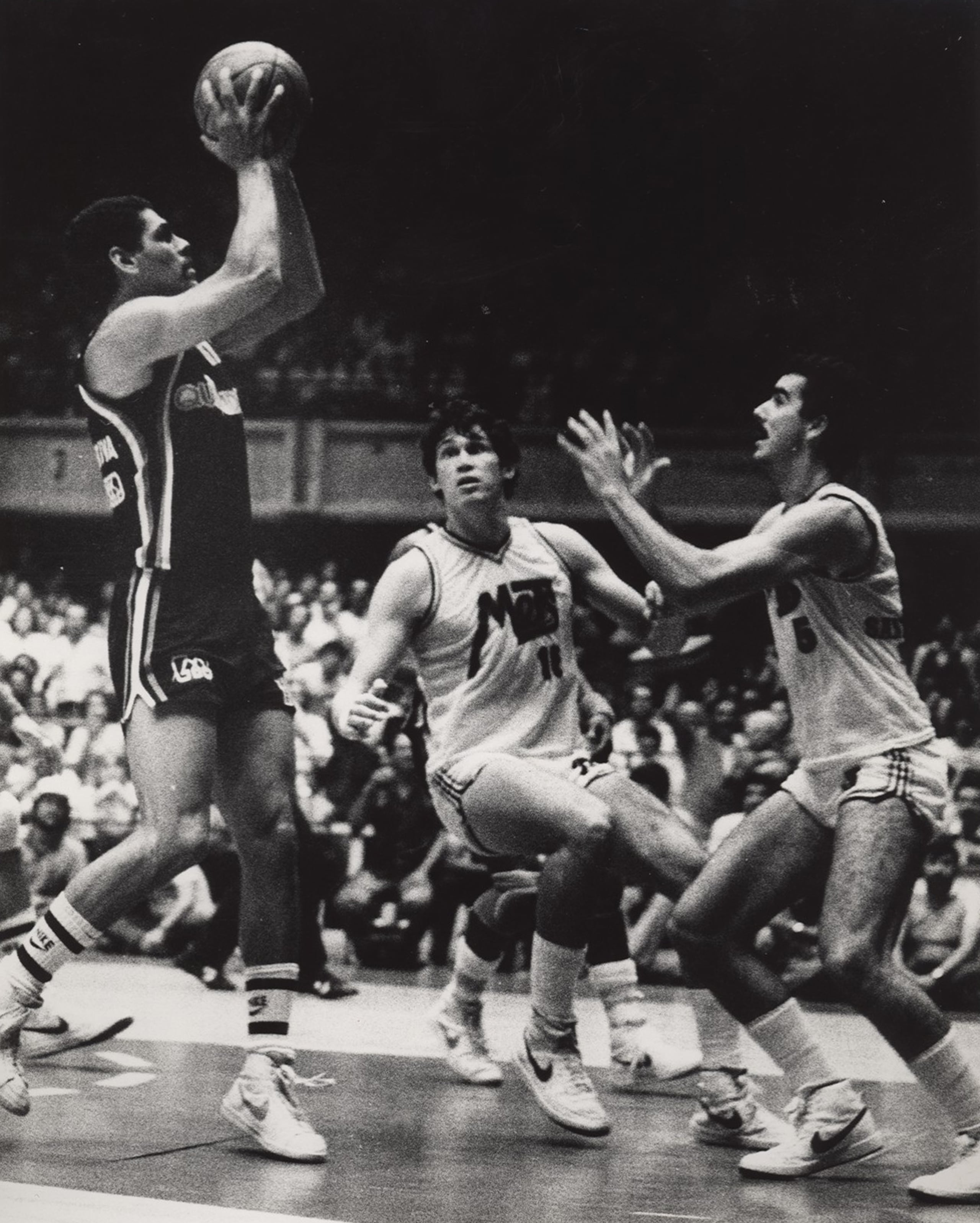Raymond Dalmau, de los Piratas de Quebradillas, maneja el balón ante Mario "Quijote" Morales, al centro, y Federico "Fico" López, de los Mets de Guaynabo, durante la campaña de 1982.