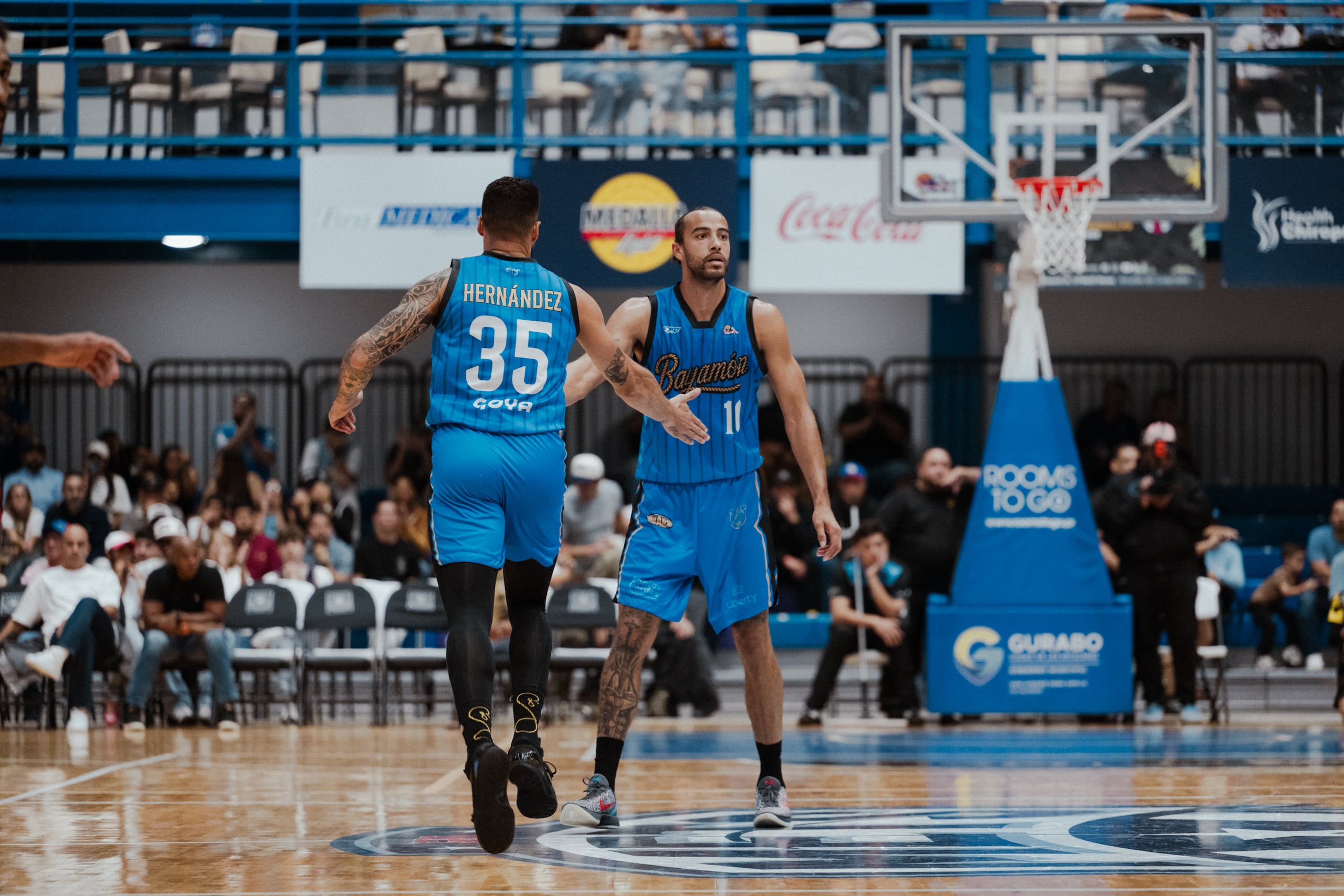 Xavier Cooks festeja un canasto con su compañero Luis "Pelacoco" Hernández durante un juego entre los Vaqueros de Bayamón y los Mets de Guaynabo.