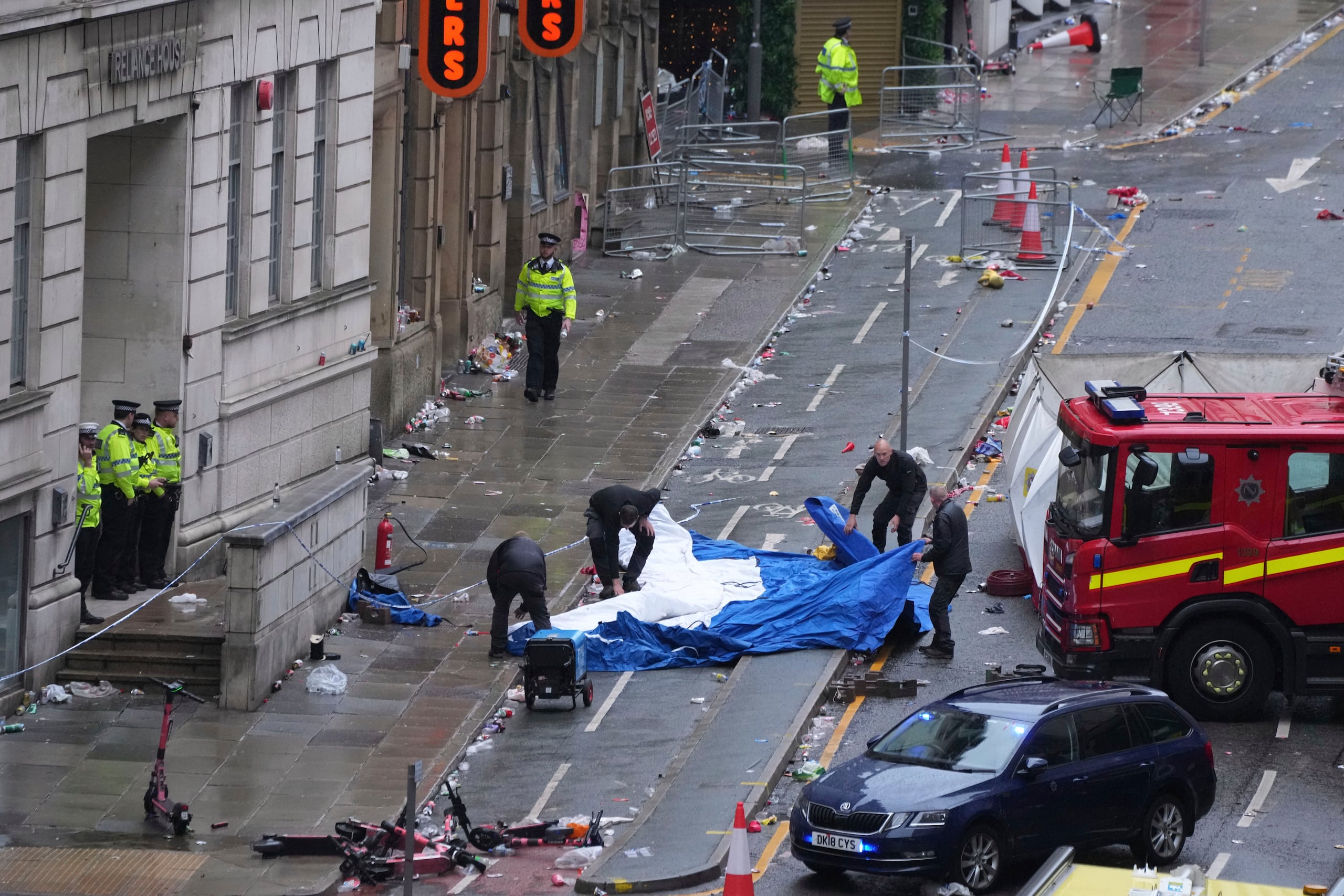 Police and emergency personnel deal with an incident after a car collided with pedestrians near the Liver Building during the Premier League winners parade in Liverpool, England, Monday, May 26, 2025.(AP Photo/Jon Super)