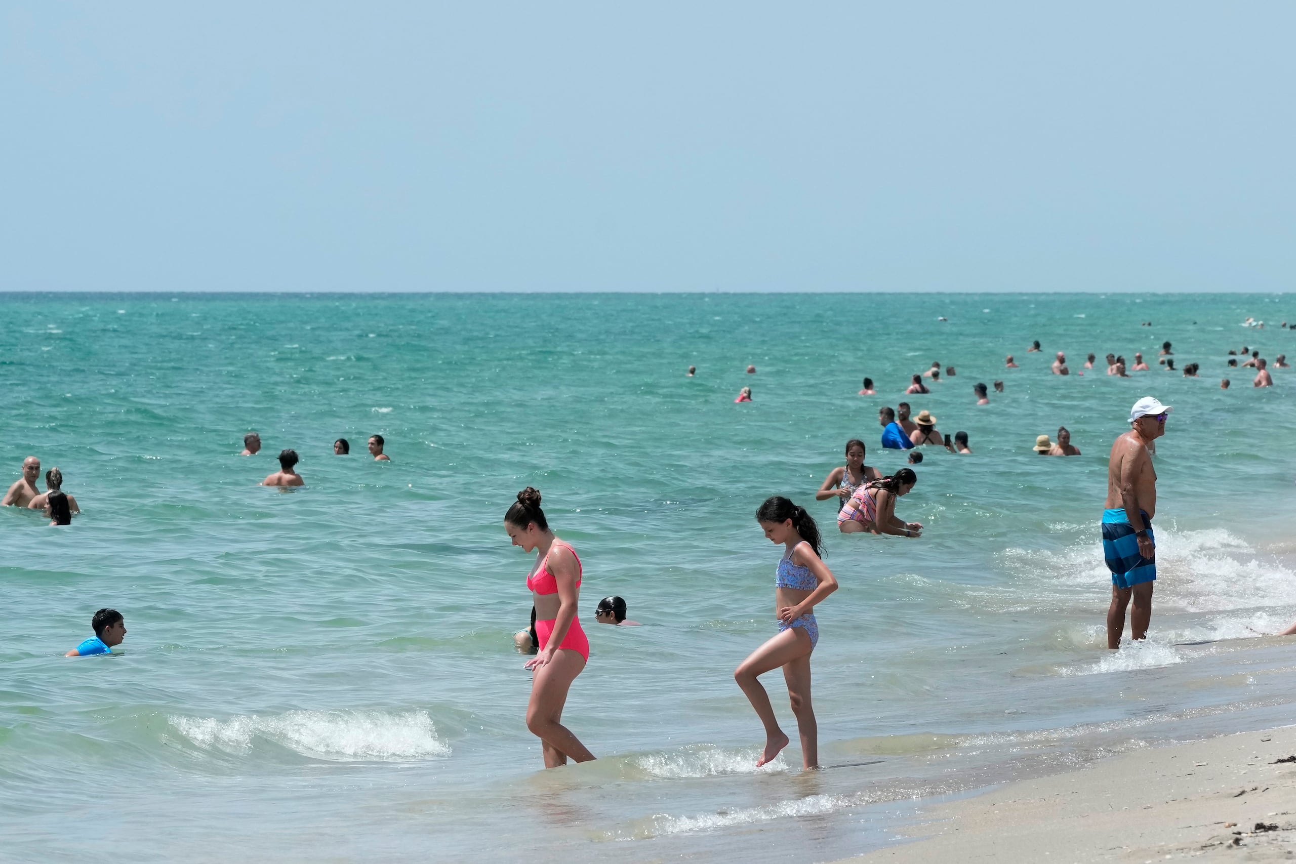 Bañistas se refrescan en aguas del Océano Atlántico, el lunes 10 de julio de 2023, en Hollywood Beach, Florida. (AP Foto/Wilfredo Lee)
