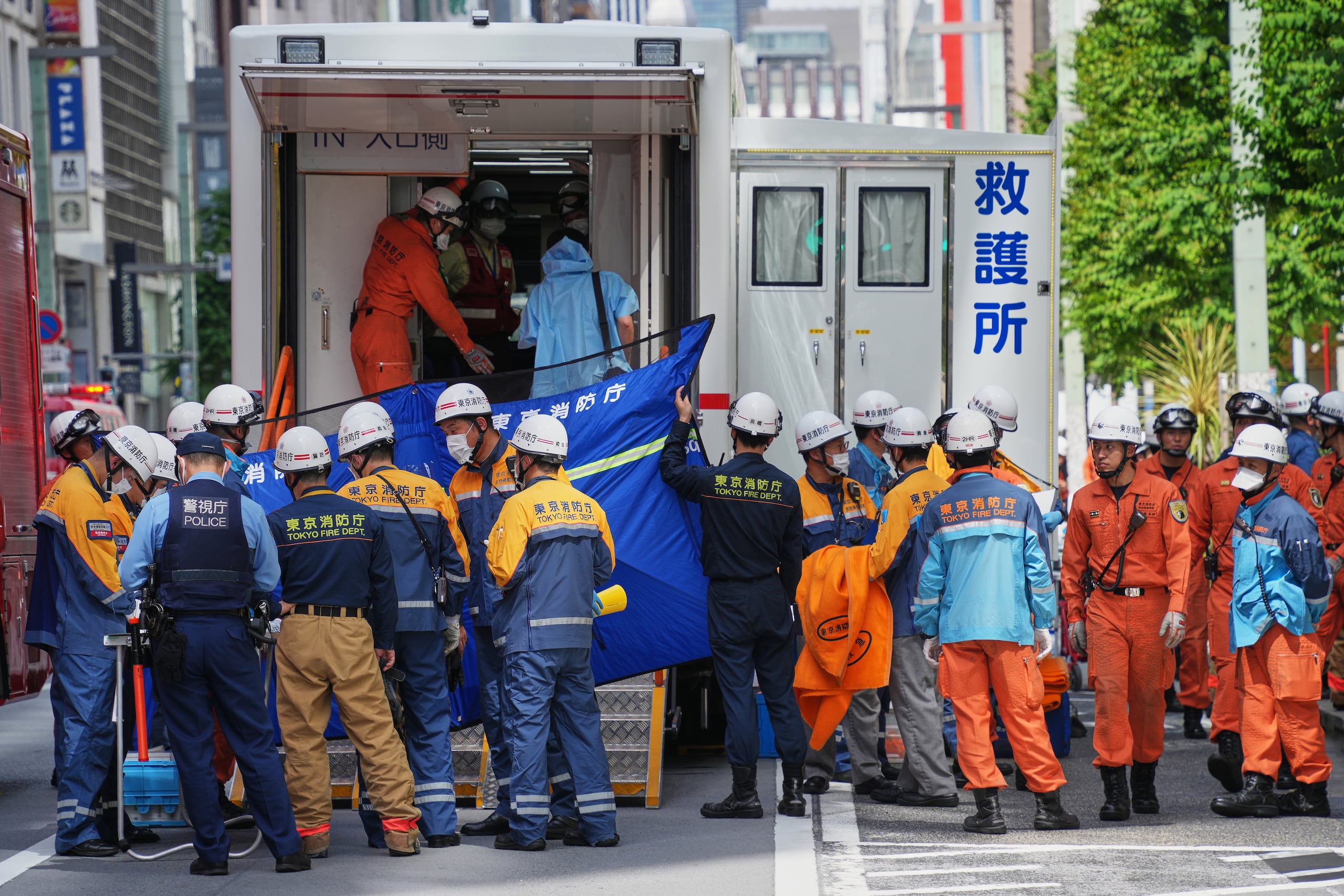 Trabajadores de emergencias se reúnen después de que una persona supuestamente rociara una sustancia que causó olor en Tokio, Japón, el lunes 25 de mayo de 2026. (AP Foto/Eugene Hoshiko)