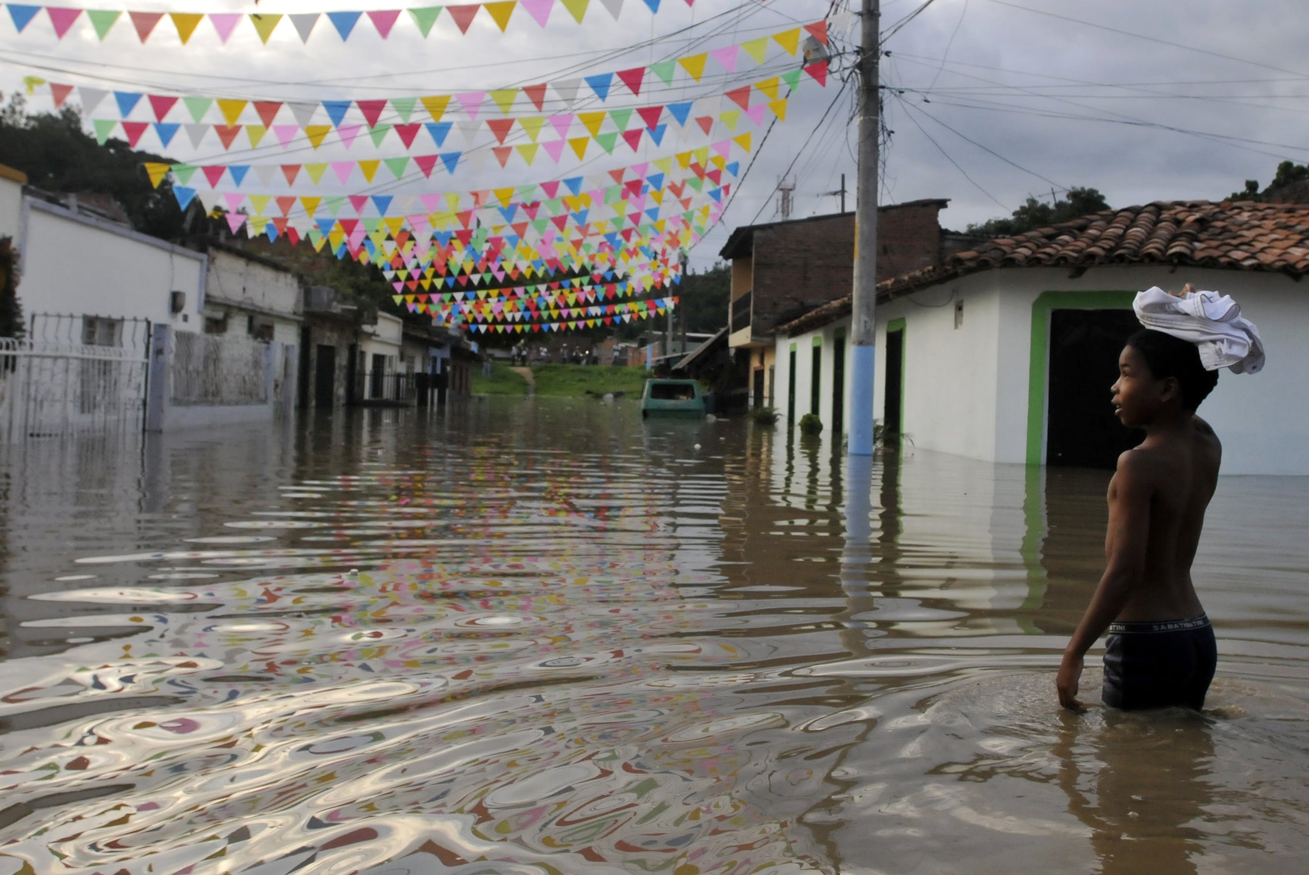 Un niño camina por una calle hoy inundada como consecuencia del fenómeno climatológico de "La Niña". EFE/CHRISTIAN ESCOBAR MORA