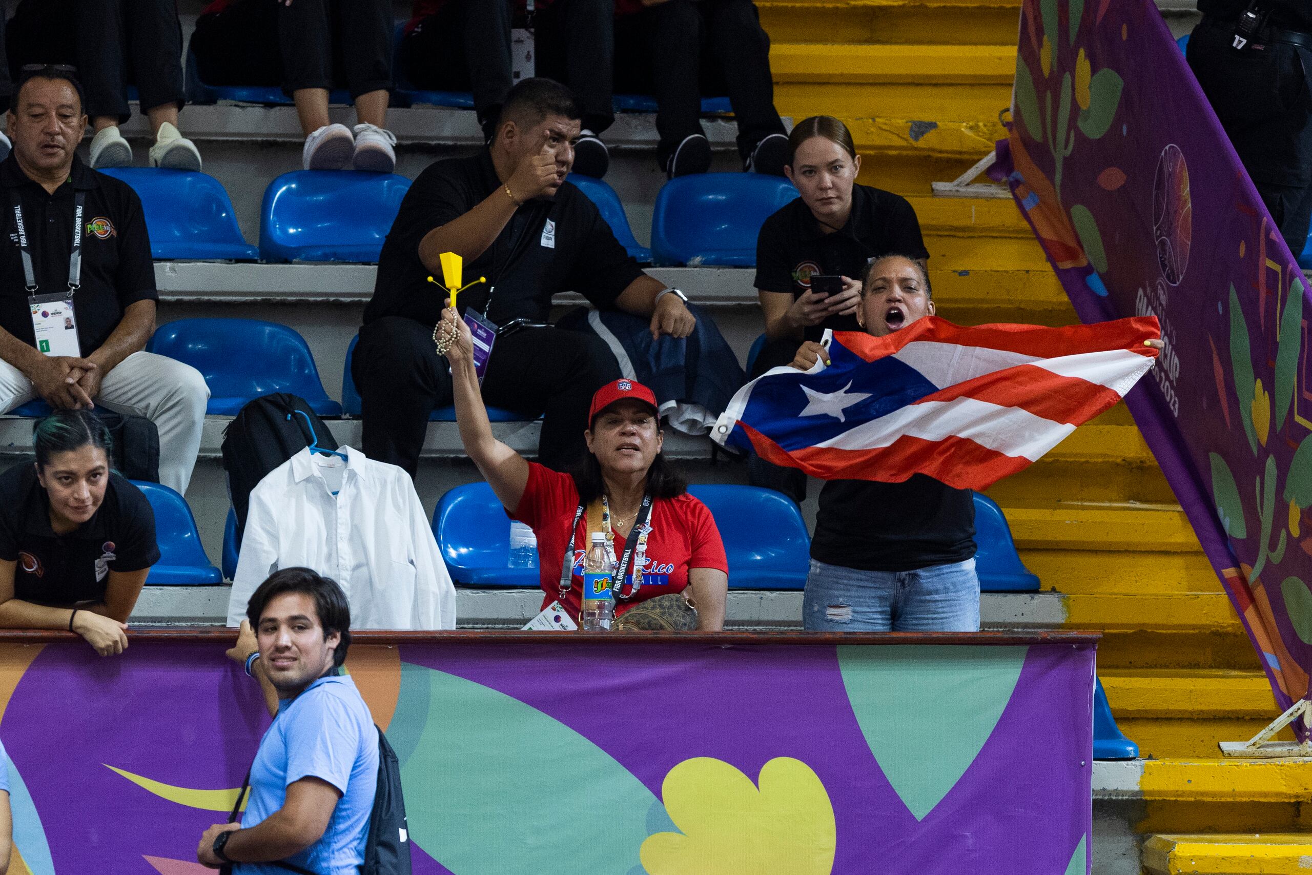 Un grupo de fanáticos de Puerto Rico alientan al equipo desde las gradas.