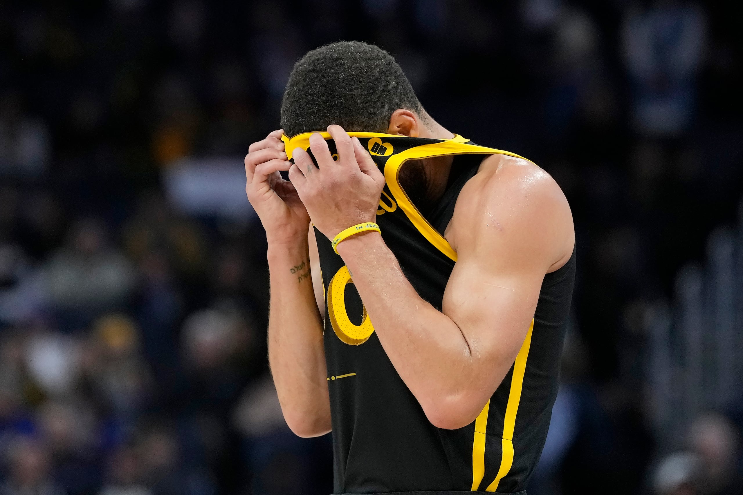 El base de los Warriors de Golden State Stephen Curry se cubre la cara con la camiseta durante el encuentro ante los Pacers de Indiana el viernes 22 de marzo del 2024. (AP Foto/Jeff Chiu)