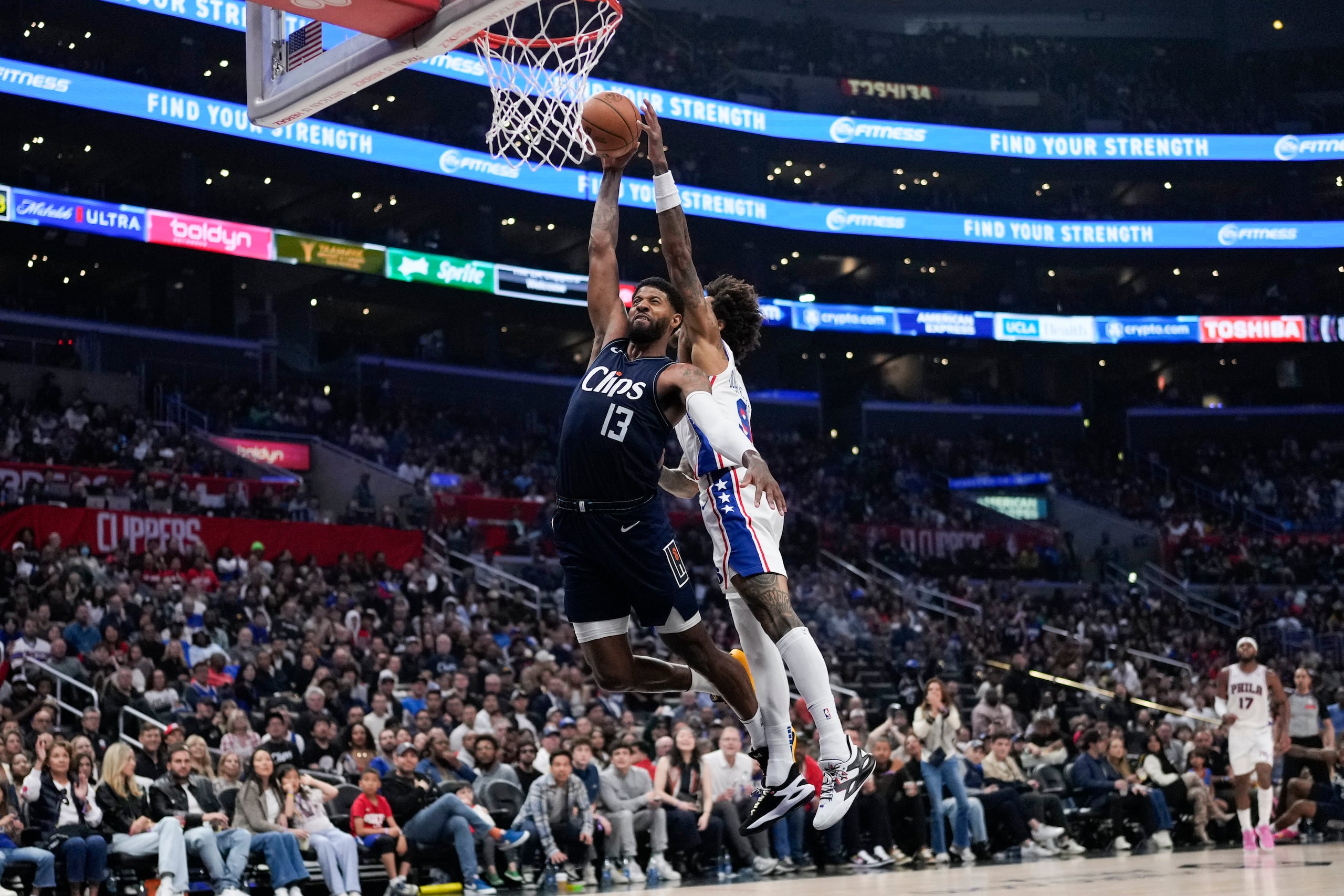 Kelly Oubre Jr. (9), de los Sixers de Filadelfia, le bloque un intento ofensivo a Paul George (13), de los Clippers de Los Ángeles,