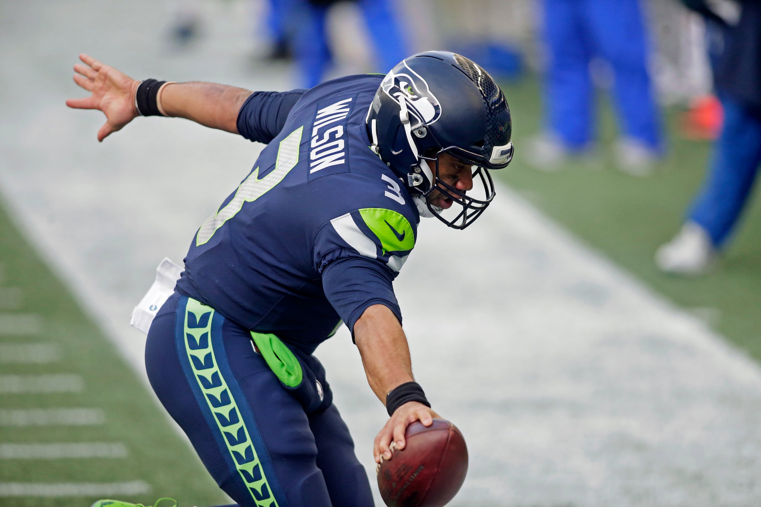 El quarterback de los Seahawks, Russell Wilson, se extiende hacia el 'end zone' durante una carrera de anotación que realizó el domingo ante los Rams de Los Angeles.