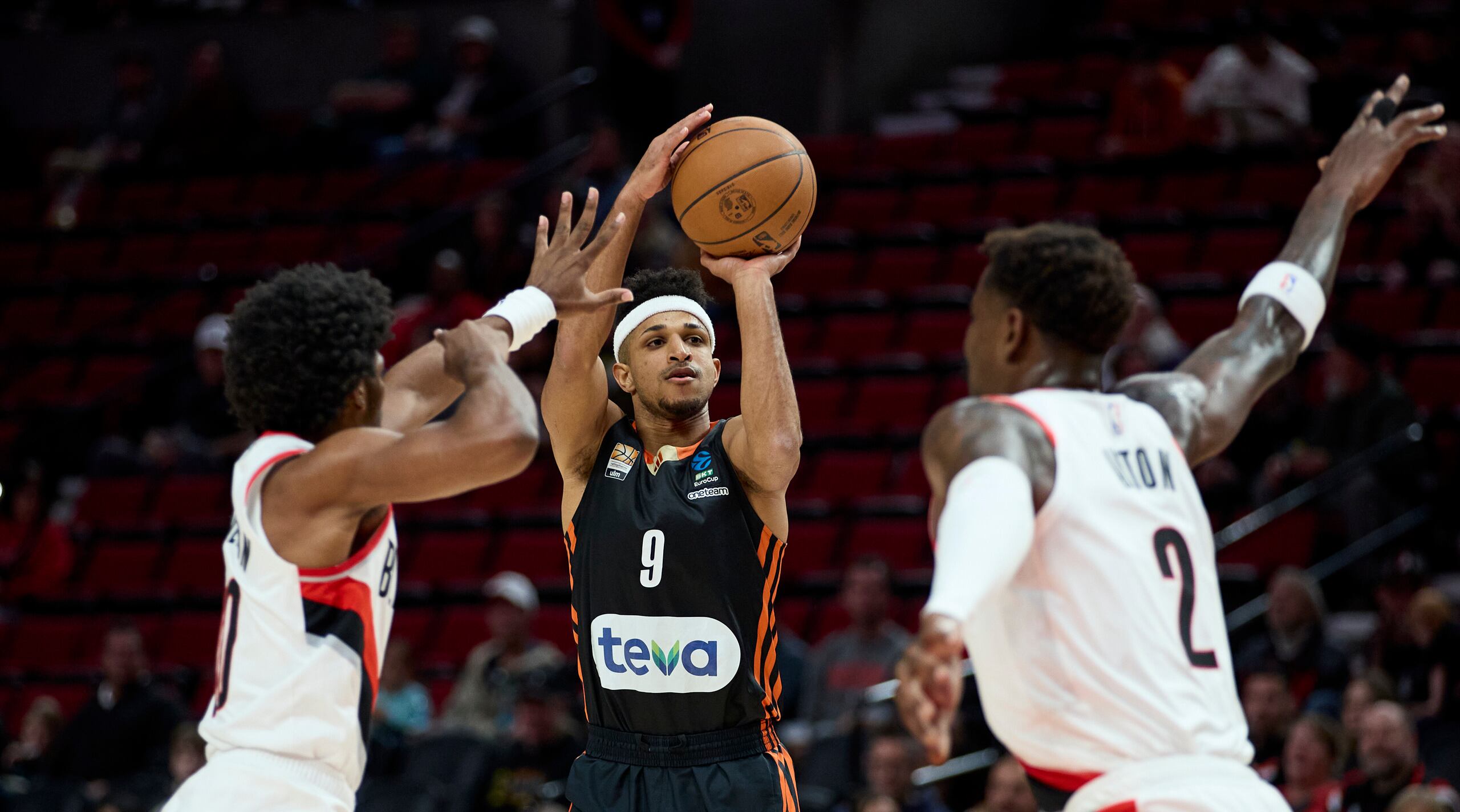 Alfonso Plummer, al centro, lanza ante Scoot Henderson, a la izquierda, y Deandre Ayton durante un juego de exhibición entre los Trail Blazers de Portland y el club alemán Ratiopharm Ulm.