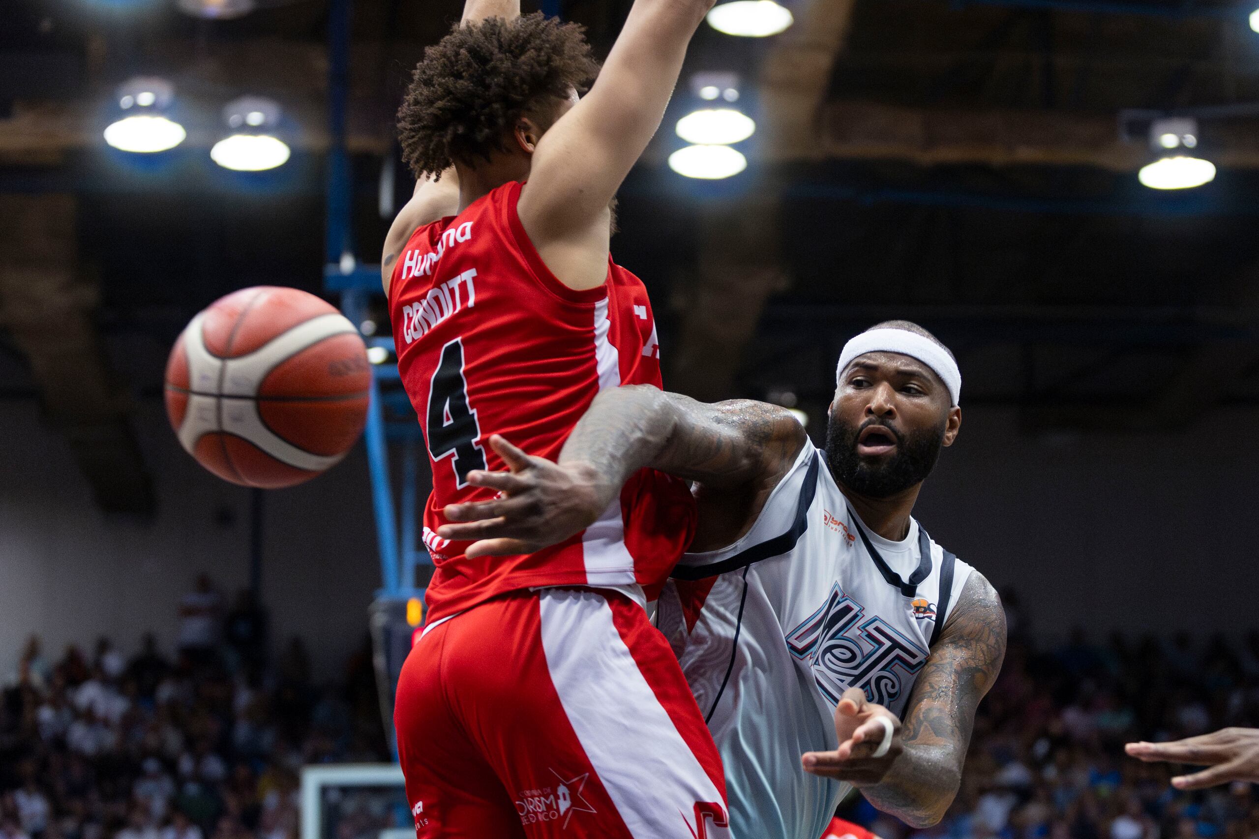 DeMarcus Cousins, de los Mets de Guaynabo, pasa el balón ante la presión de George Conditt IV, de los Gigantes de Carolina-Canóvanas.
