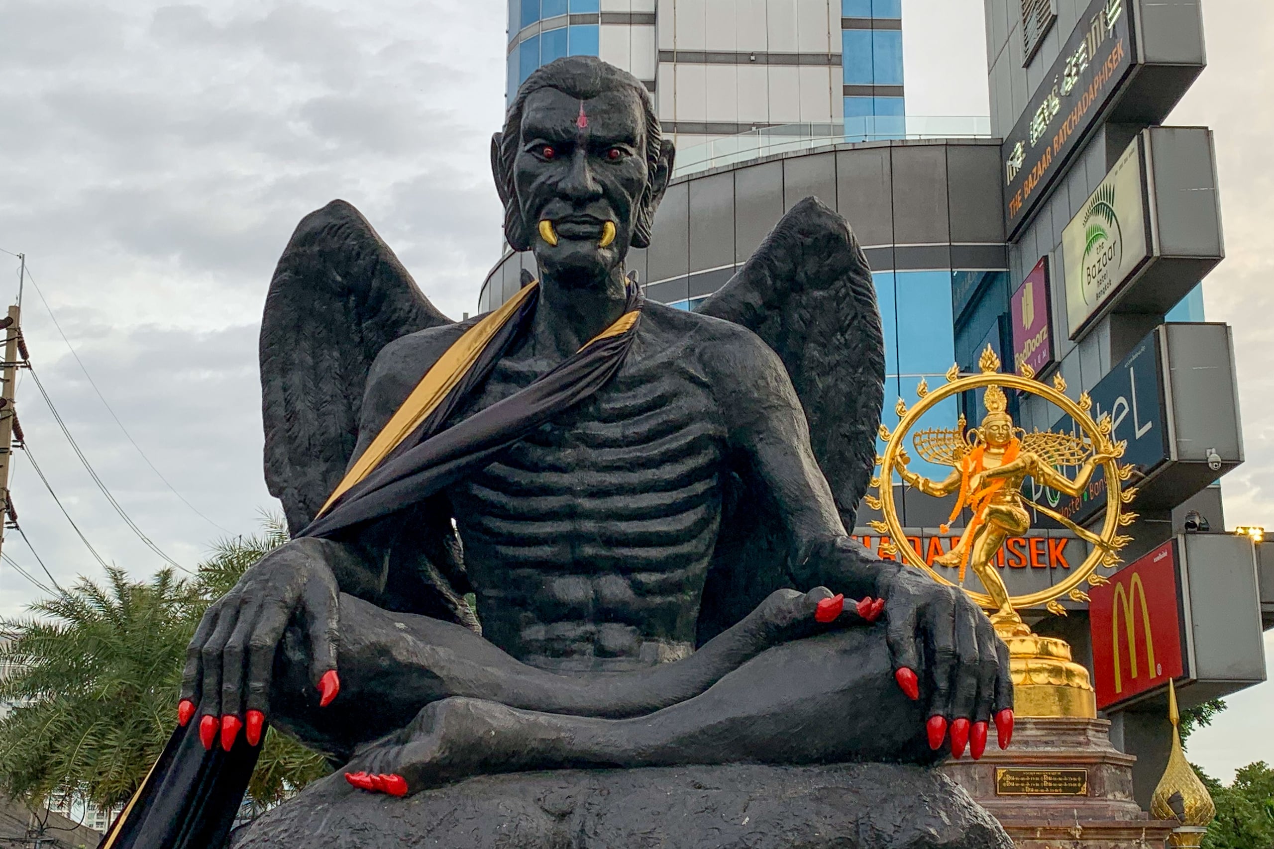 La estatua representa a Kru Kai Kaew, al que sus seguidores identifican con un antiguo maestro de magia esotérica que vivió bajo la corte de Jayavarman VII, el primer rey budista del Imperio jemer entre los años 1181 y 1218, aunque algunos expertos aseguran que se trata de una leyenda sin fundamento histórico.