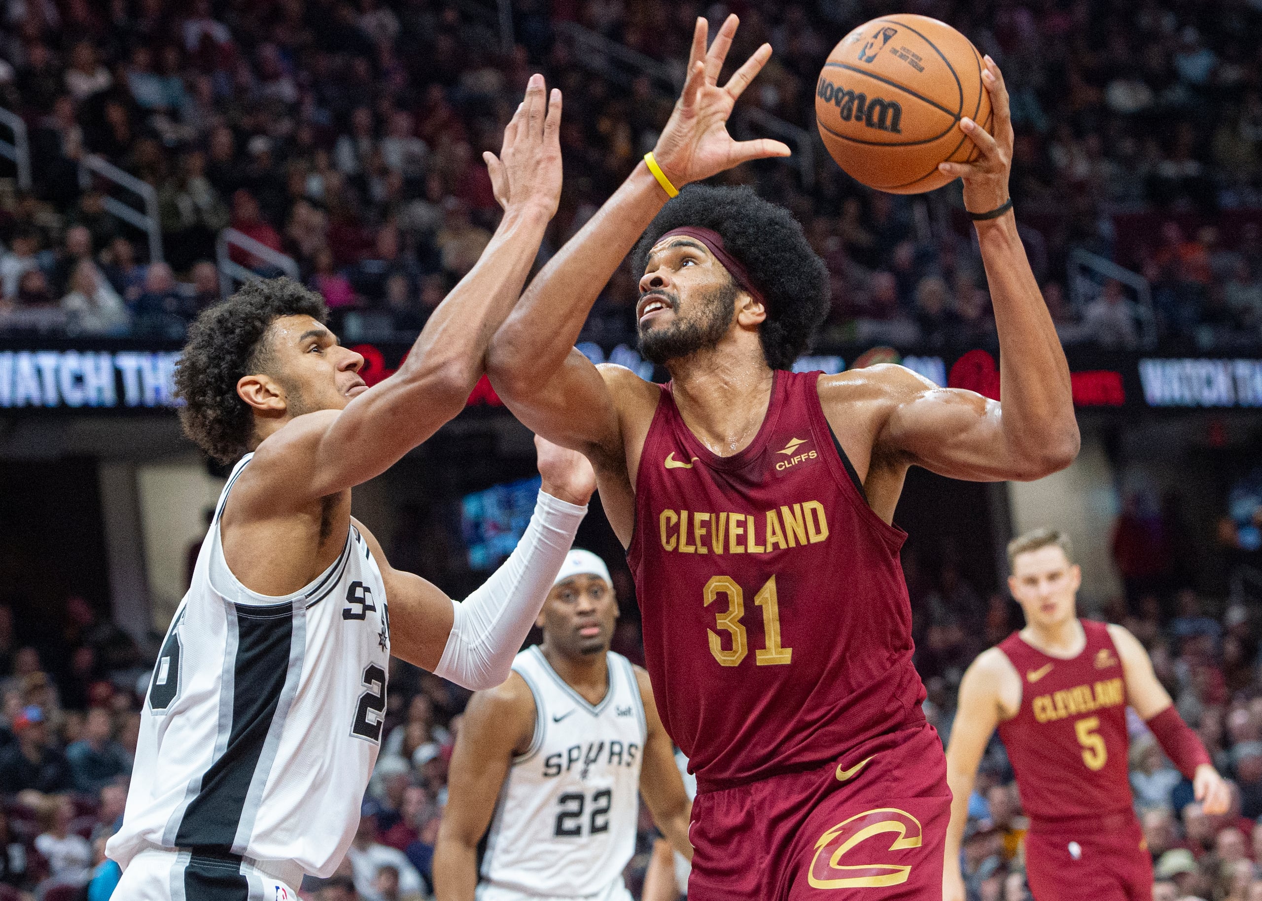 Jarrett Allen (31), de los Cavaliers de Cleveland, ataca la canasta frente la marca defensiva de Dominick Barlow, izquierda, de los Spurs de San Antonio, durante la segunda mitad del juego de baloncesto de la NBA en Cleveland, el domingo 7 de enero de 2024.