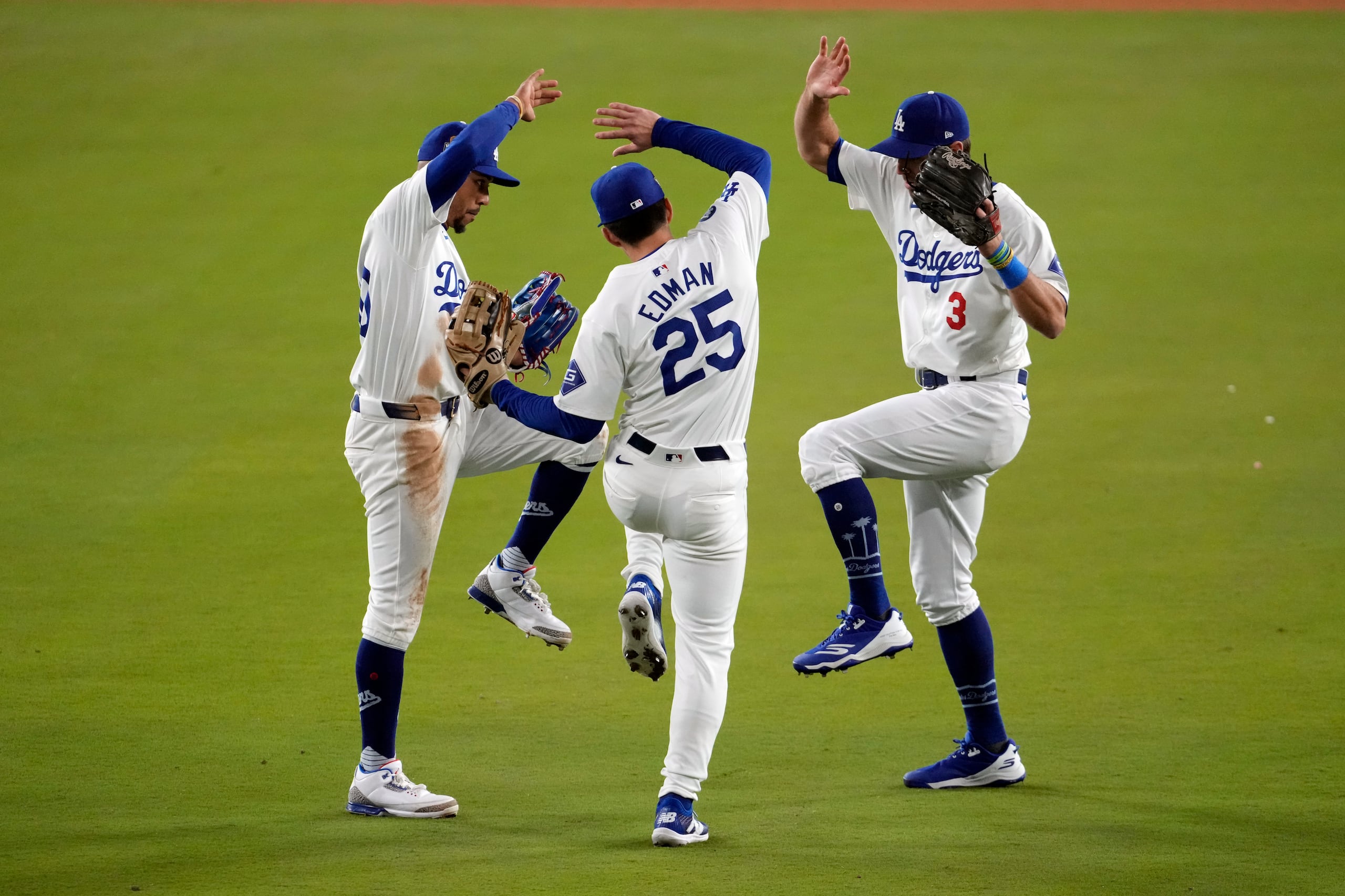 Chris Taylor, Tommy Edman y Mookie Betts, de los Dodgers de Los Ángeles, celebran tras ganar el segundo encuentro de la Serie Mundial ante los Yankees de Nueva York el sábado.