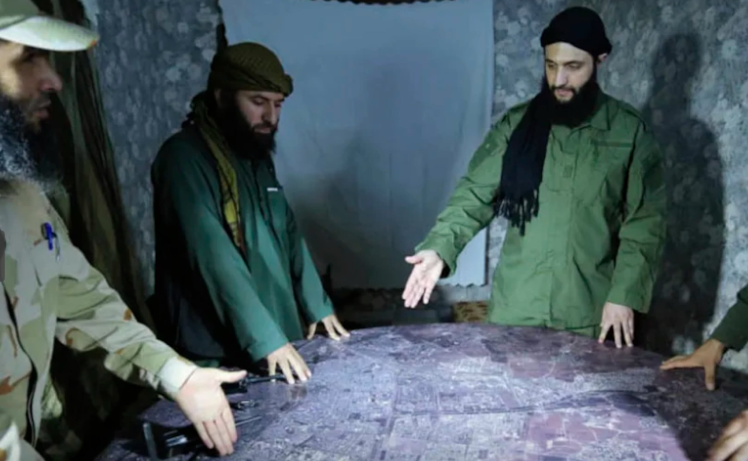 En esta imagen de archivo sin fecha, distribuida por un grupo insurgente en 2016, se muestra a Abu Mohammed al-Golani, a la derecha, vestido de verde. (Imagen de grupo insurgente vía AP, Archivo)