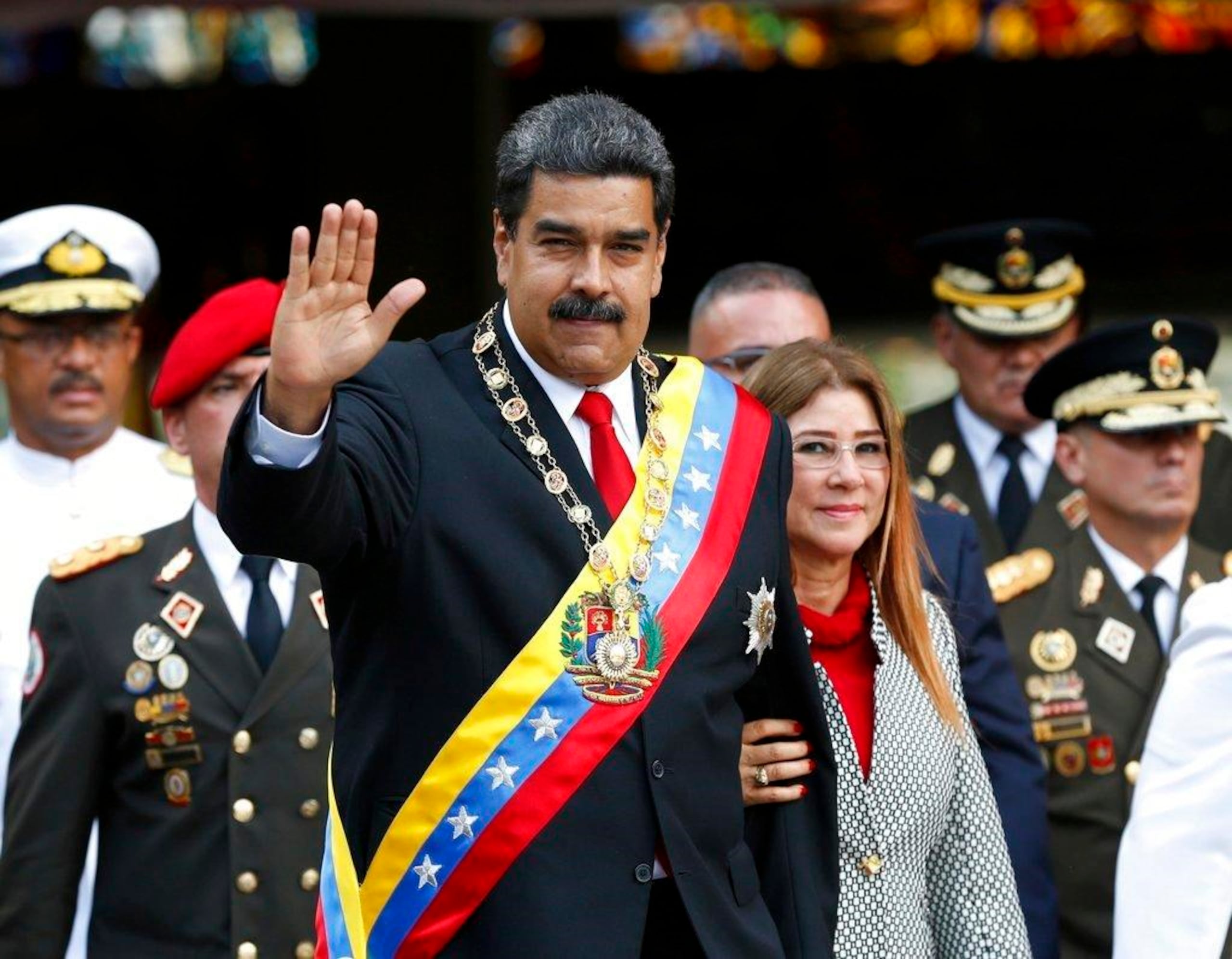 Nicolás Maduro y su esposa, Cilia Flores, saludan a su llegada a un desfile militar en el Fuerte Tiuna en Caracas. (AP)