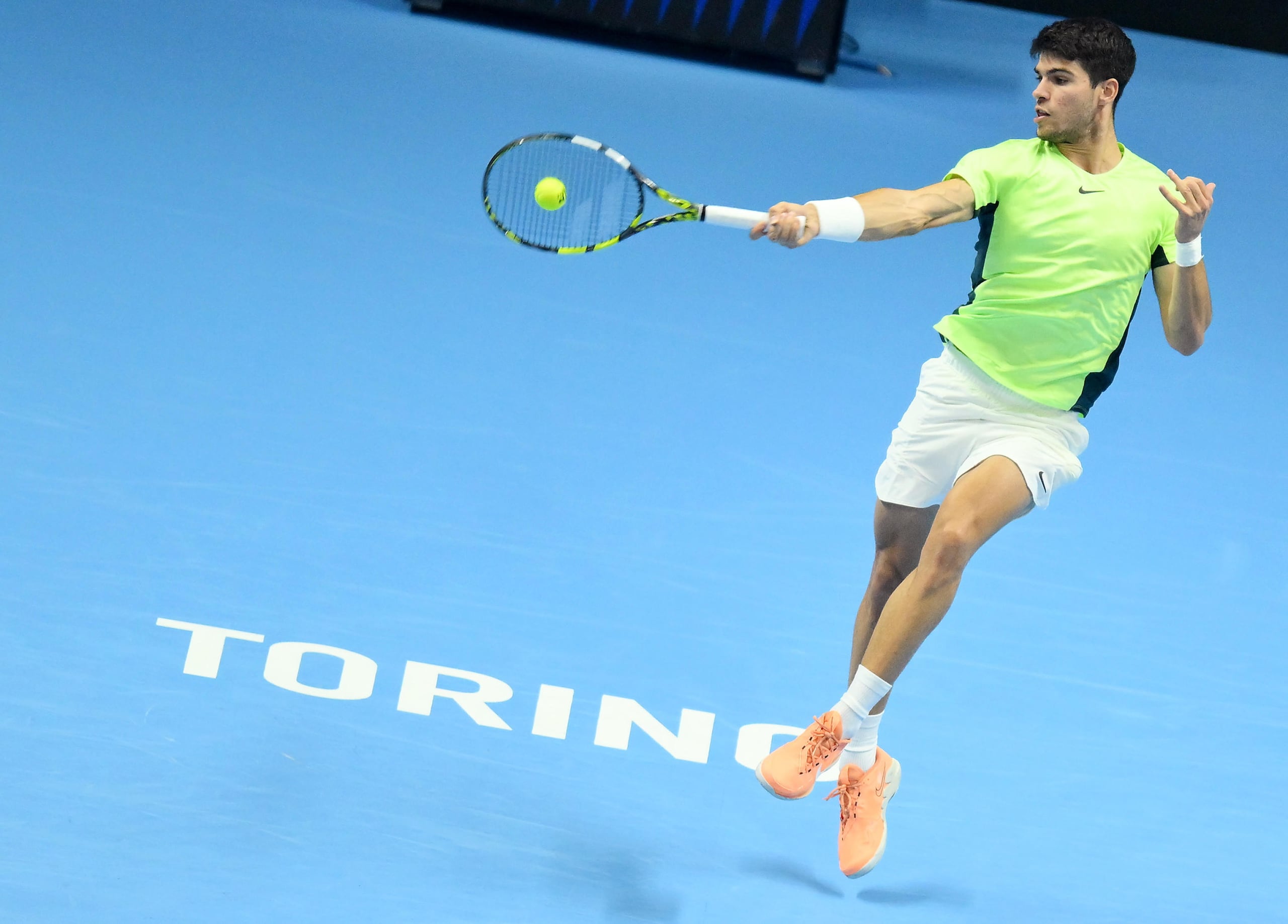 Carlos Alcaraz le pega a la pelota durante el enfrentamiento contra Novak Djokovic en las semifinales de la Copa de Maestros en Turín, Italia.