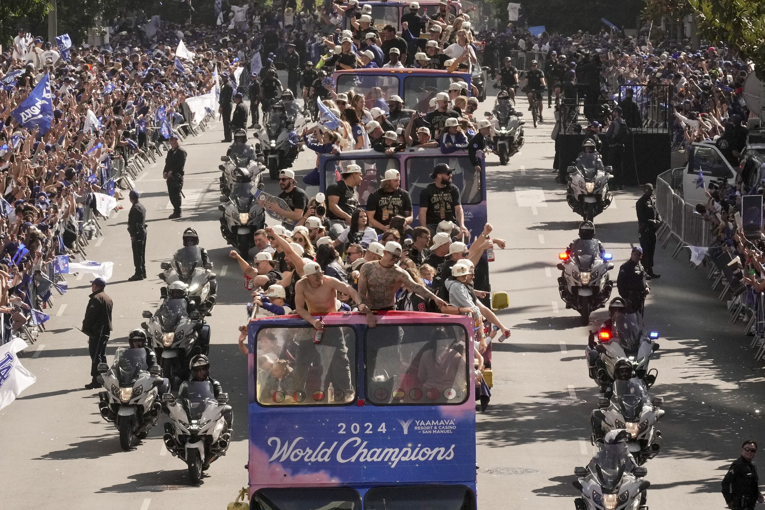 El puertorriqueño Kike Hernández (centro) encabeza la parada de los Dodgers en autobús por las calles de Lo Angeles.