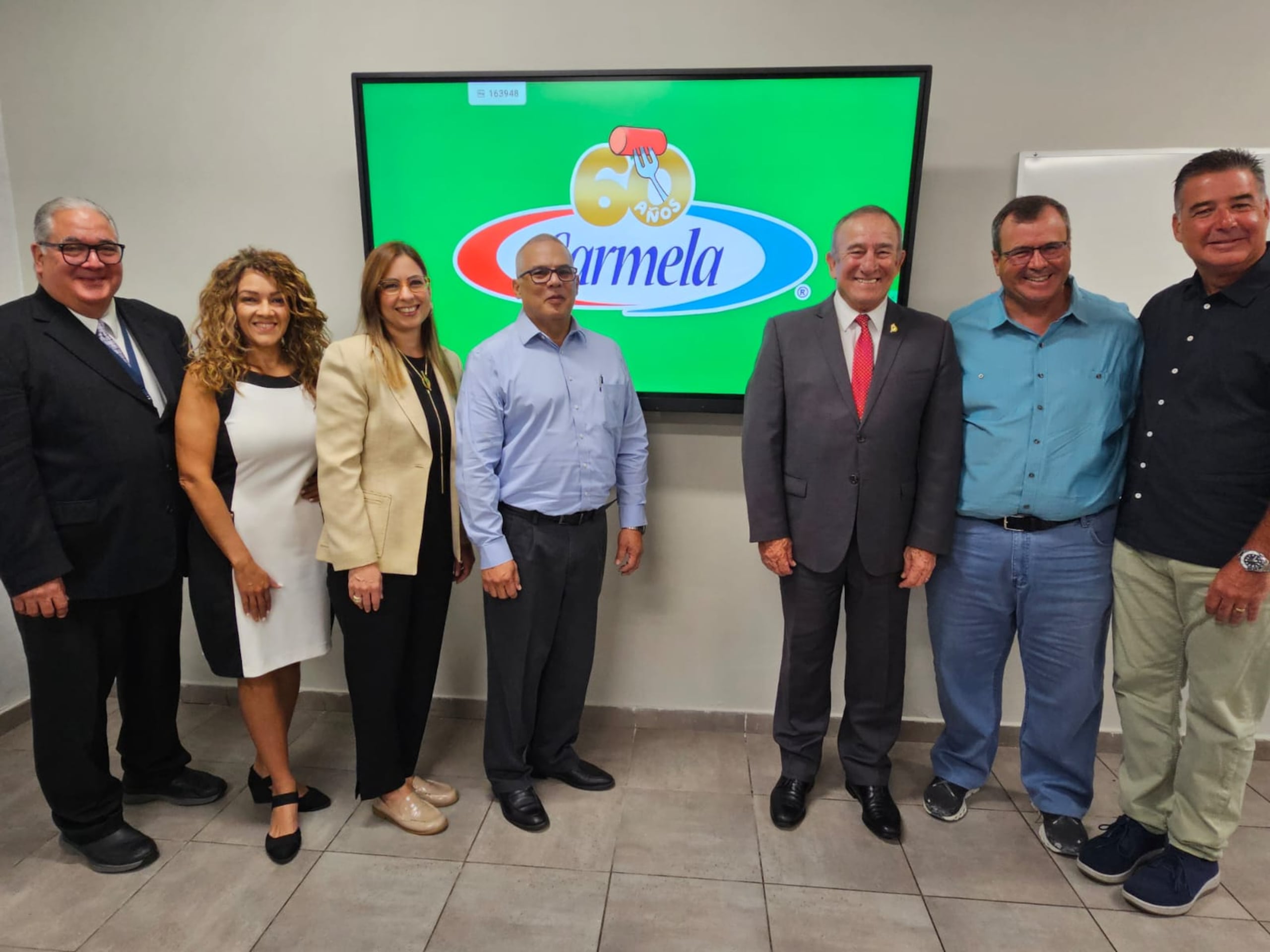 El secretario del DDEC, Manuel Cidre (con gabán y corbata roja), visitó la planta Carmela y se reunió con su dueño, el empresario Alberto de la Cruz, a su lado y ejecutivos de la empresa.