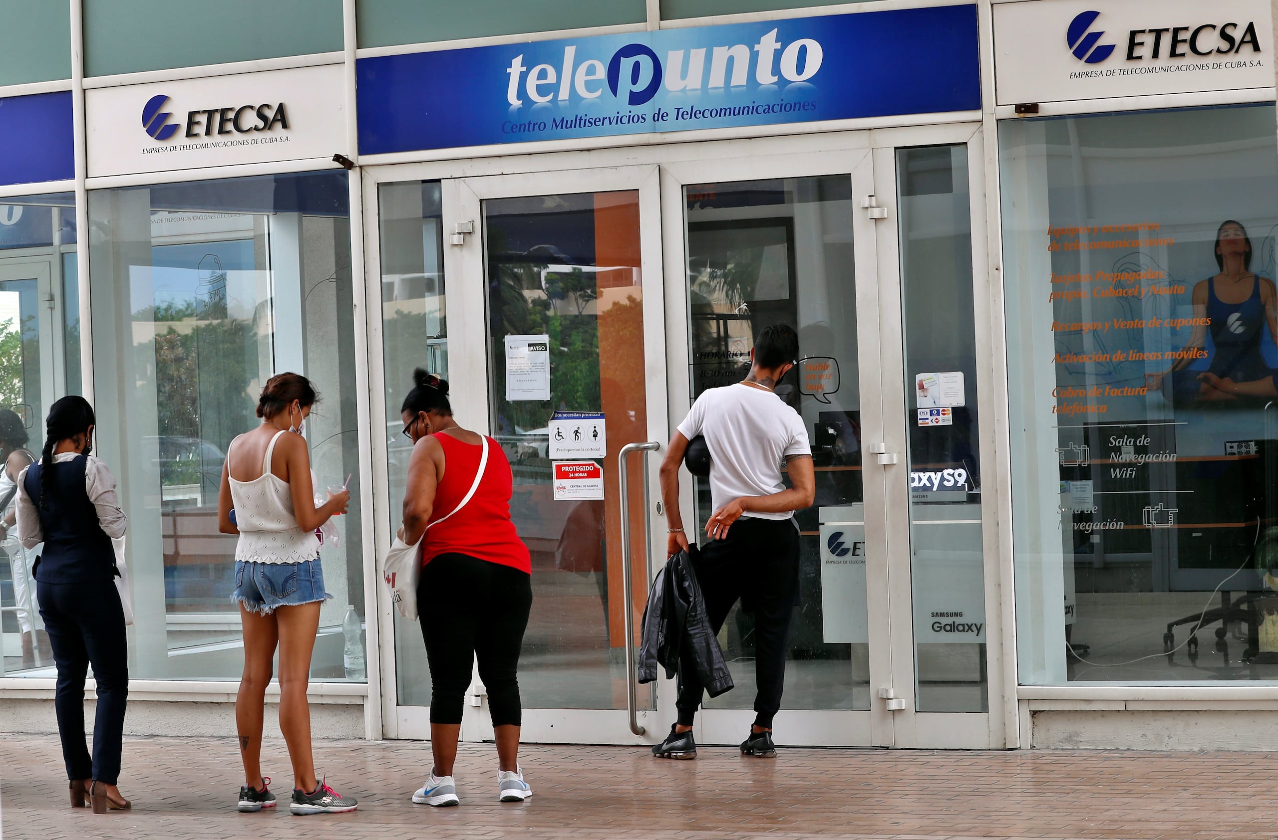 Fotografía de archivo de varias personas esperando para entrar a una oficina de servicios de la Empresa cubana de telecomunicaciones (ETECSA), en La Habana (Cuba). EFE/ Ernesto Mastrascusa