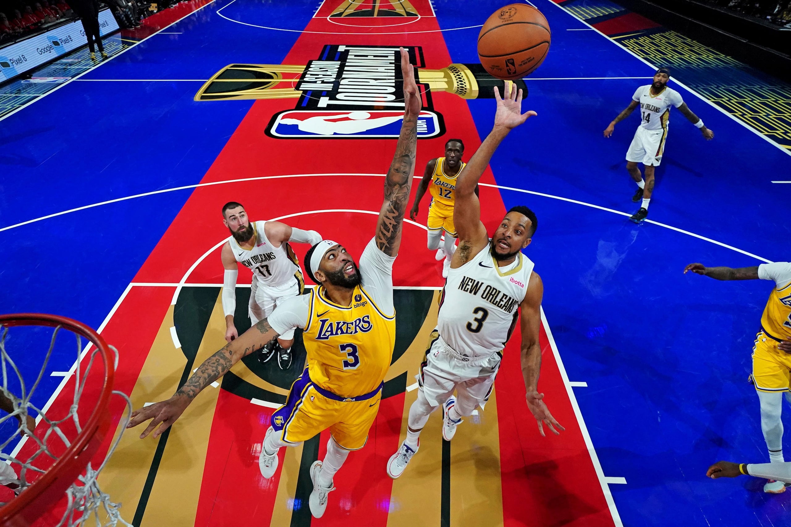 Anthony Davis, de los Lakers, busca bloquear un intento de CJ McCollum de los Pelicans de Nueva Orleans, durante la fase seminal de la Copa de la NBA, celebrada en Las Vegas. La foto muestra uno de los brillantes tabloncillos sobre los cuales se jugaron los partidos.