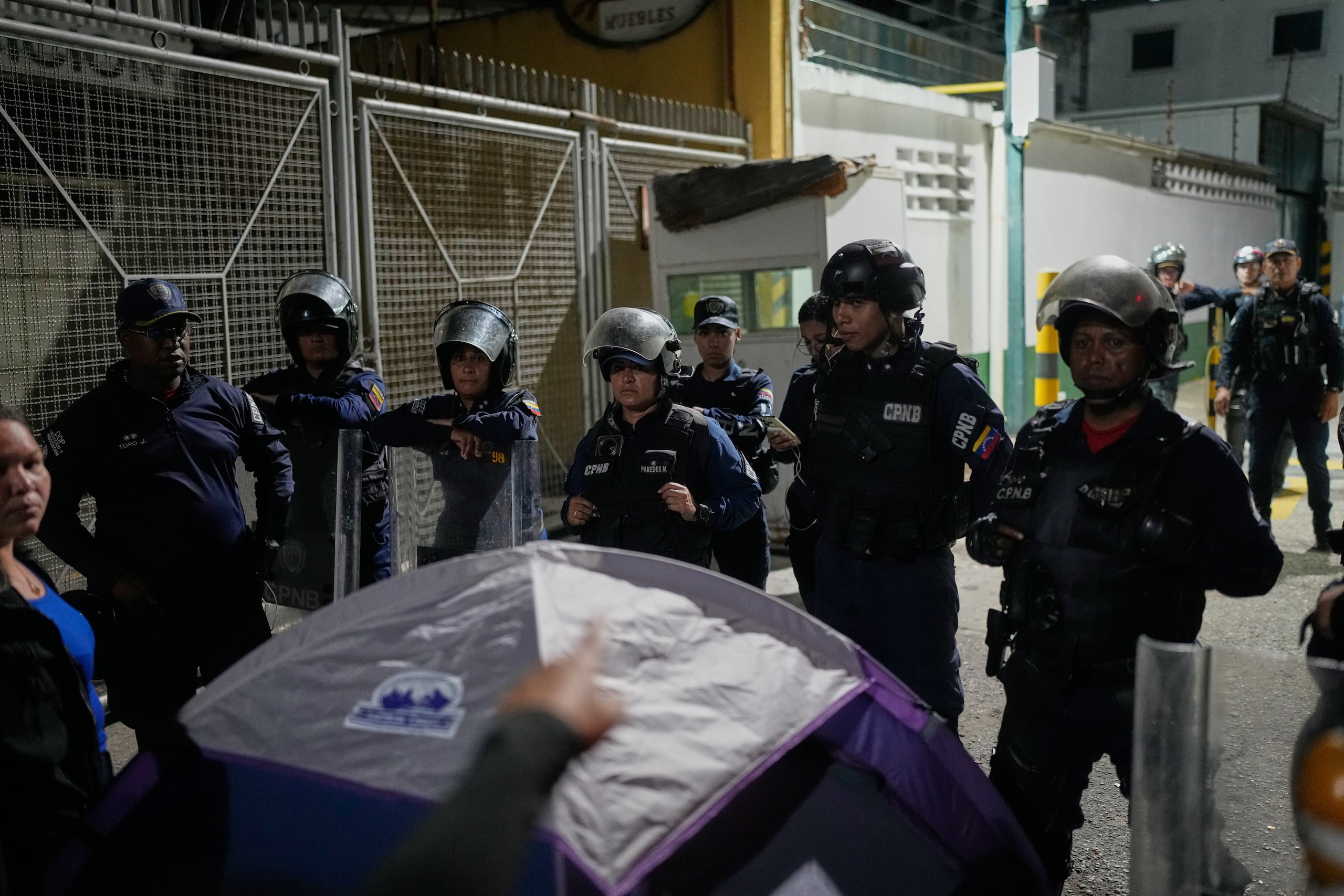 Un familiar de un preso político señala a la policía afuera del centro de detención Zona 7 de la Policía Nacional Bolivariana, el martes 20 de enero de 2026, en Caracas, Venezuela. (AP Foto/Matías Delacroix)