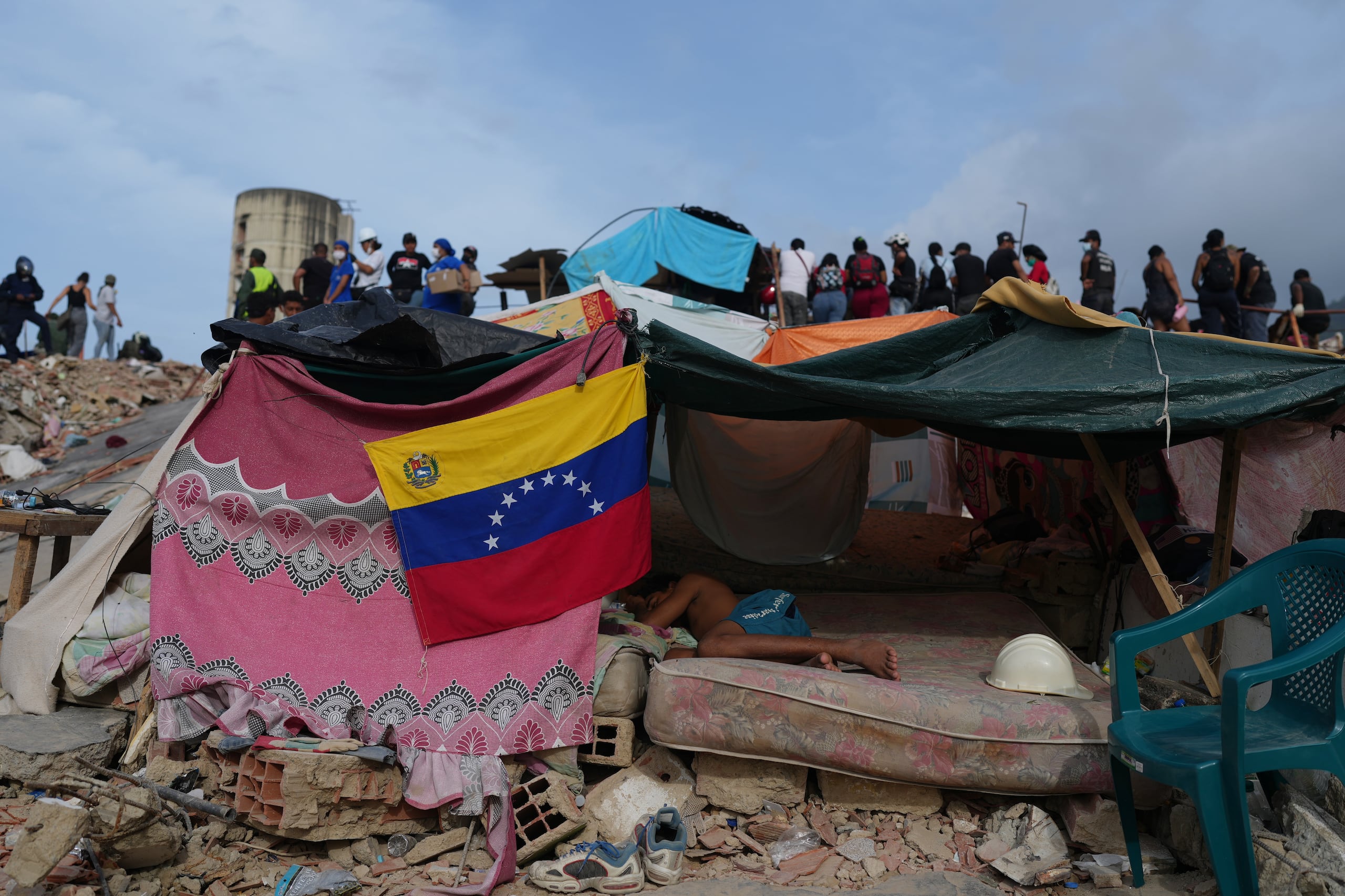 Un joven duerme mientras los rescatistas continúan buscando entre los escombros tras los terremotos en La Guaira, Venezuela, el sábado 4 de julio de 2026. (Foto AP/Ariana Cubillos)