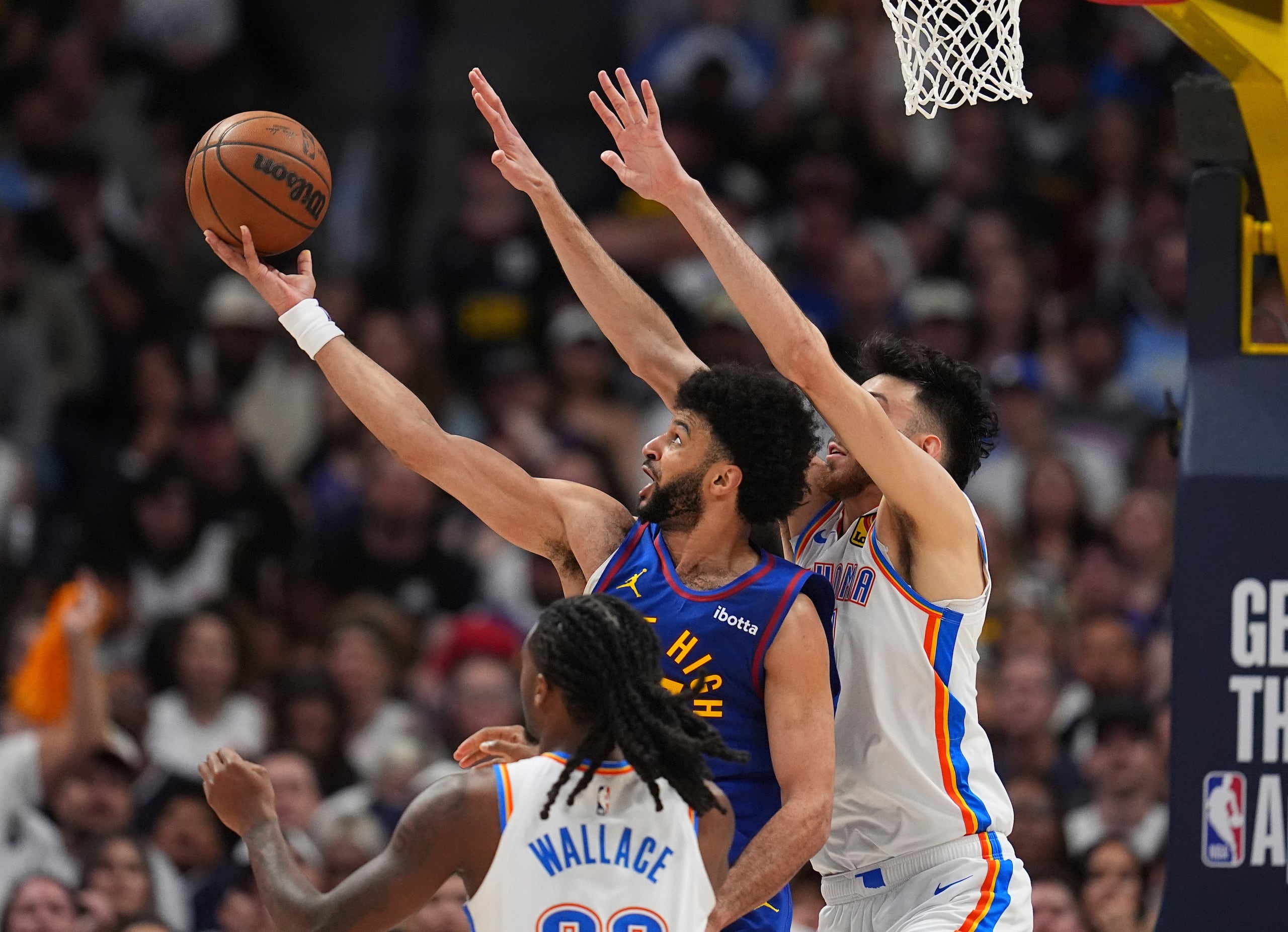 Jamal Murray, de los Nuggets de Denver, ataca el canasto ante la defensa de Cason Wallace y Chet Holmgren, ambos del Thunder de Oklahoma.