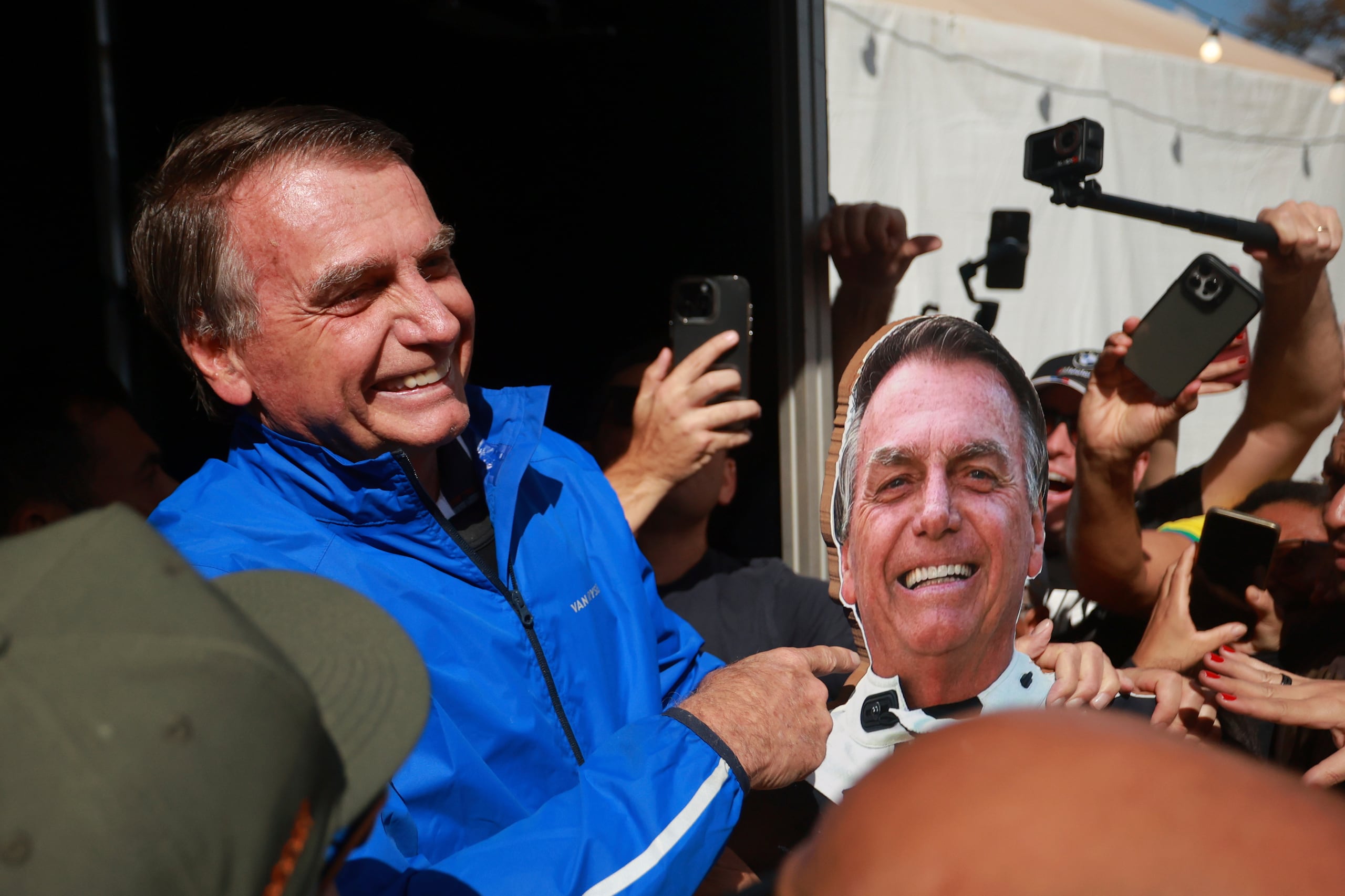 El expresidente brasileño Jair Bolsonaro señala a una foto de él el 29 de julio de 2025, en Brasilia. (AP foto/Luis Nova)