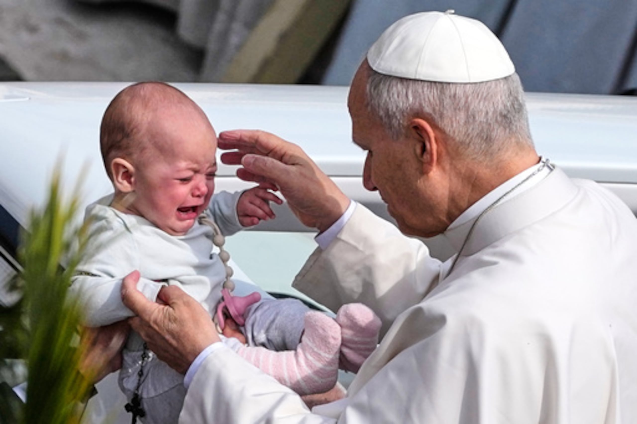 El Papa León XIV acaricia a un niño tras presidir la misa en la Plaza de San Pedro del Vaticano en la festividad católica del Domingo de Ramos, que conmemora la llegada de Jesús a Jerusalén, el domingo 29 de marzo de 2026. (AP Photo/Alessandra Tarantino)