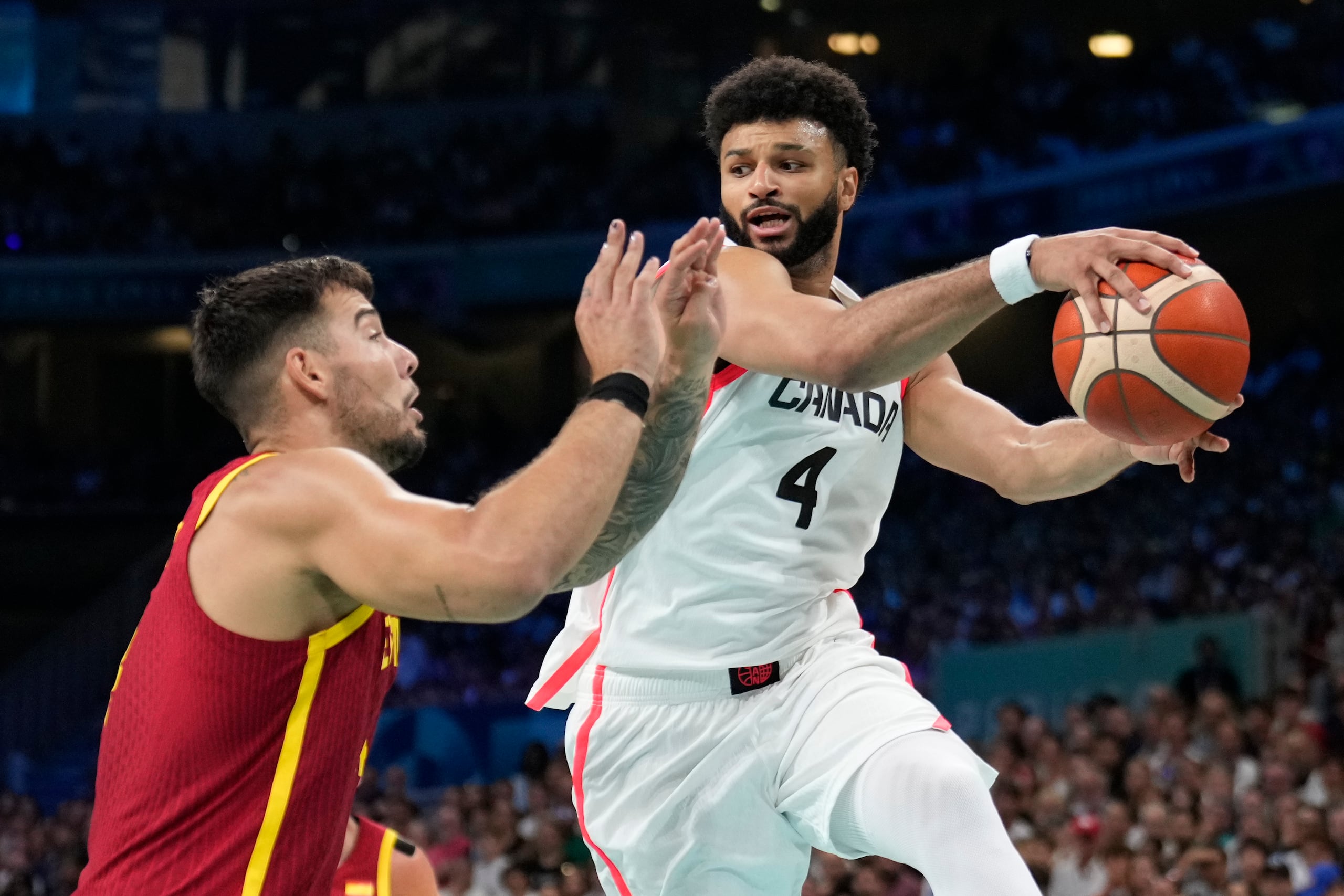 Jamal Murray (derecha) busca pasar el balón frente al español Willy Hernangómez en los Juegos Olímpicos.