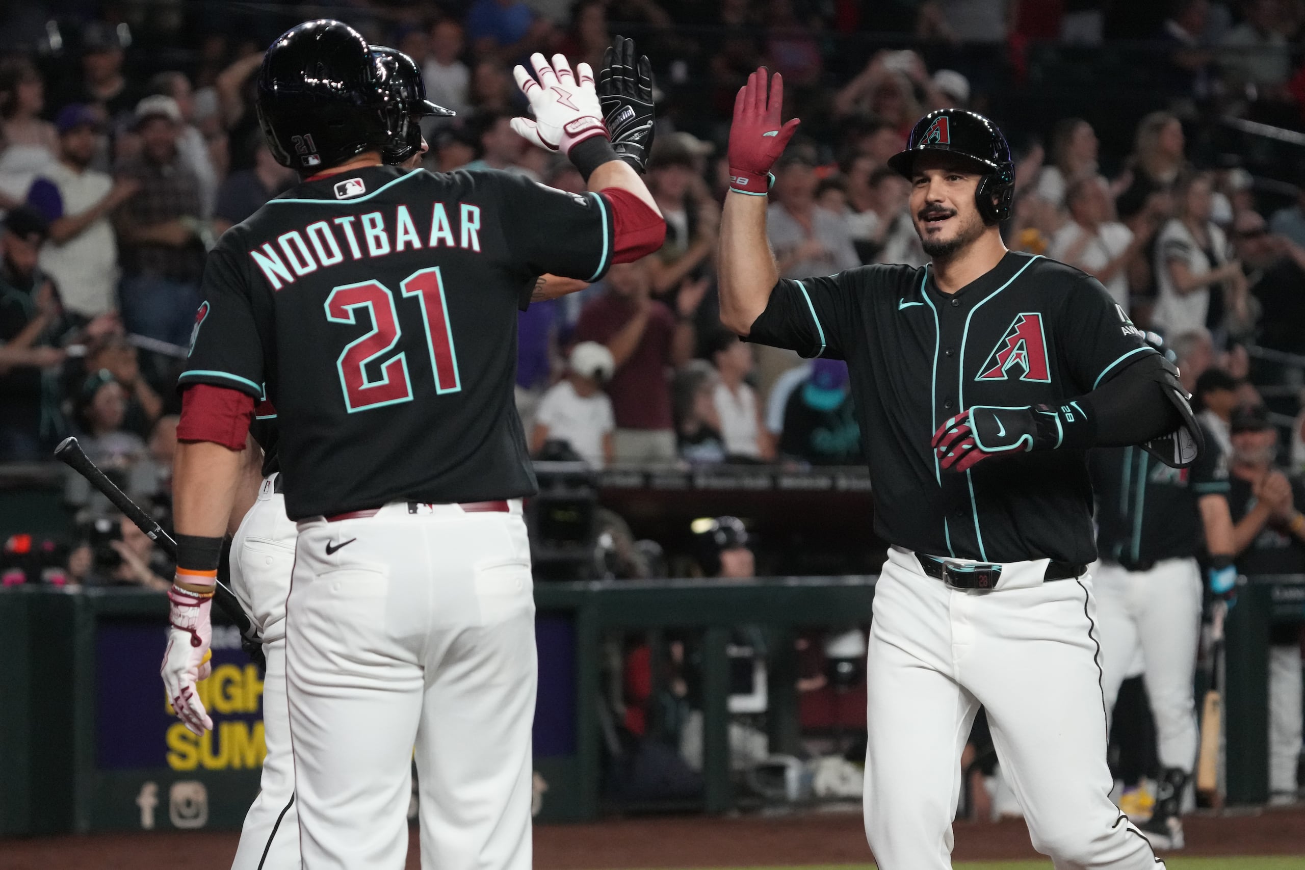 Nolan Arenado, derecha, de los Diamondbacks de Arizona, celebra con Tyler Locklear y Lars Nootbaar (21) después de conectar un grand slam contra los Rockies de Colorado en la segunda entrada.
