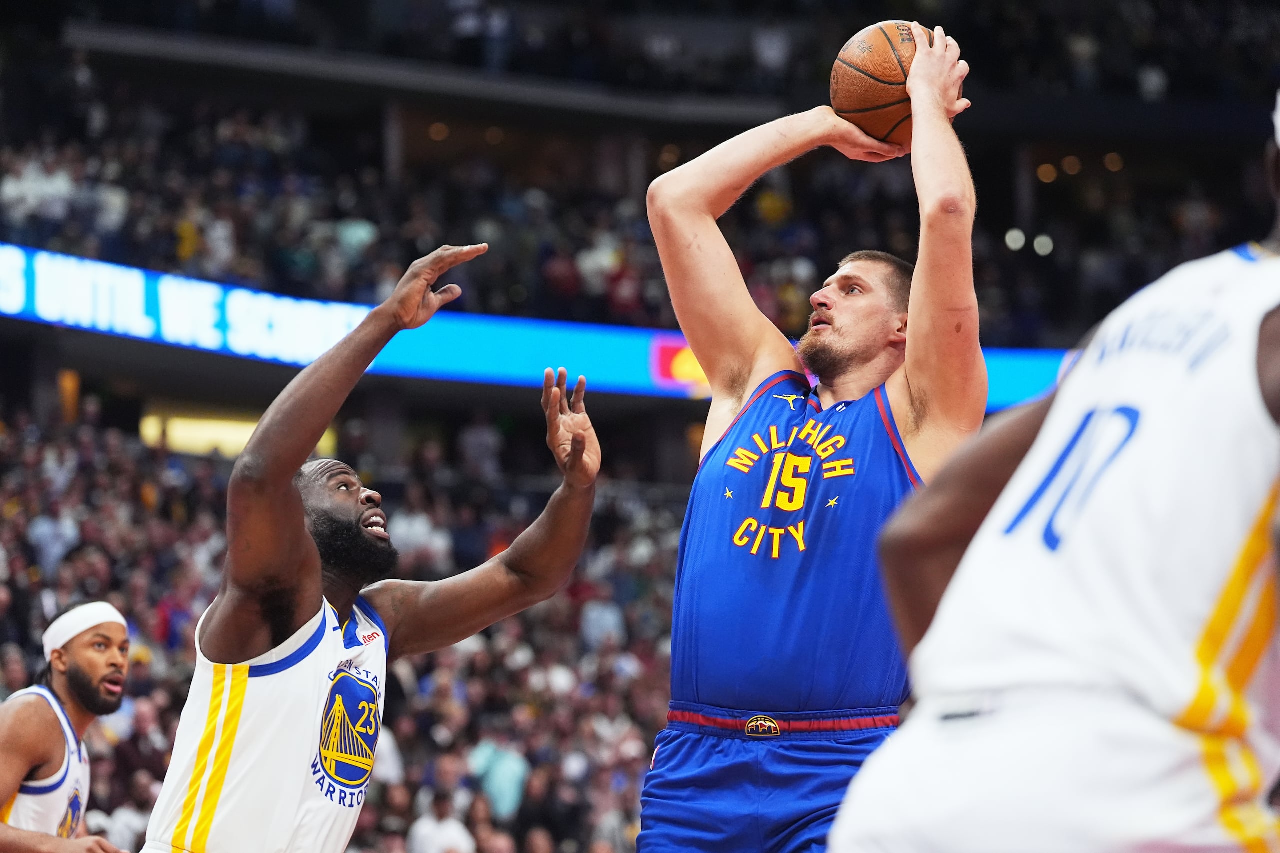 El serbio Nikola Jokic, de los Nuggets de Denver, busca disparar frente a Draymond Green, de los Warriors de Golden State, en el partido del viernes 7 de noviembre de 2025 (AP Foto/David Zalubowski)