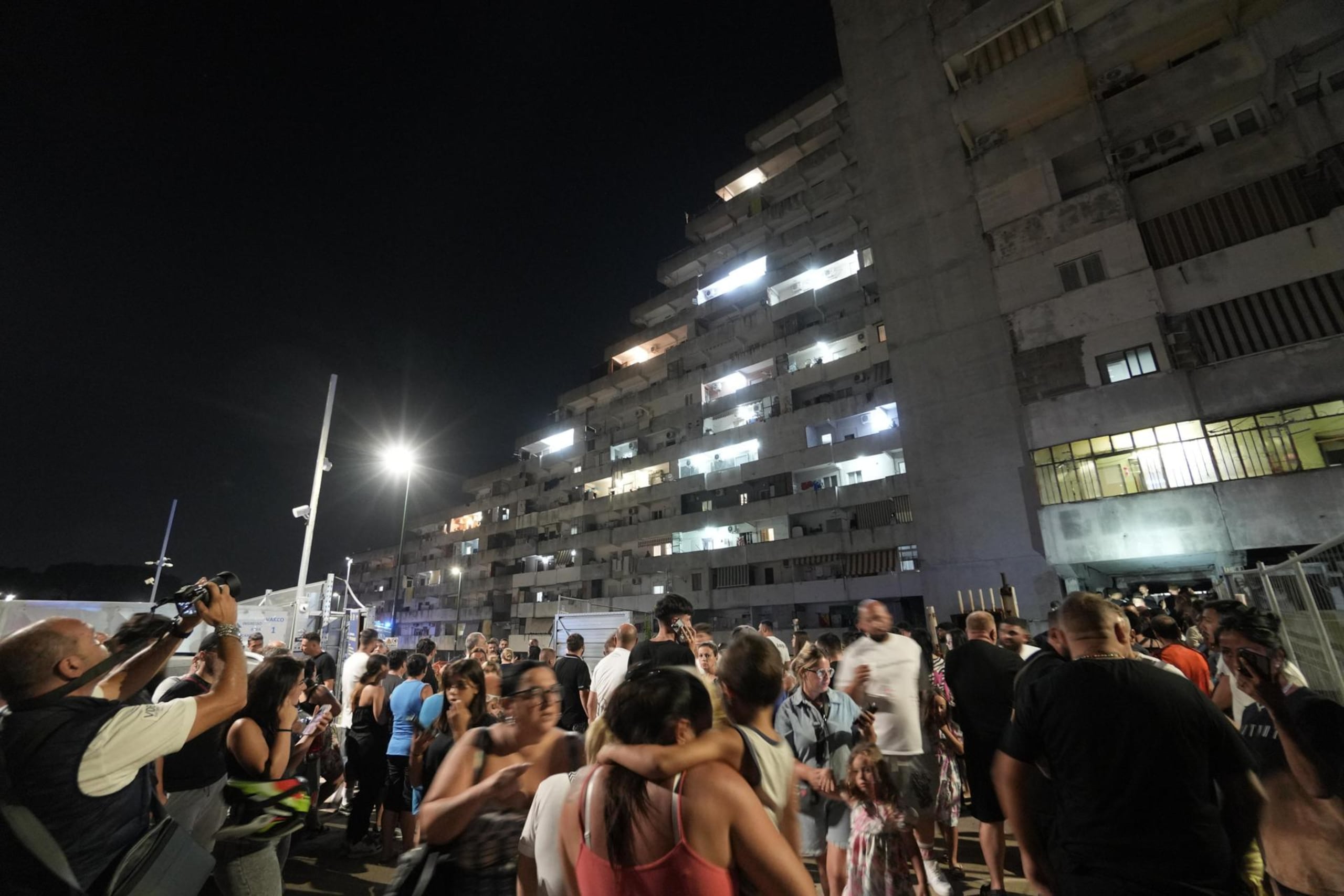 Las personas que fueron desalojadas de sus apartamentos observan después del colapso de un balcón en el complejo de viviendas Vela Celeste en Scampia, Nápoles, Italia, a última hora del 22 de julio de 2024.