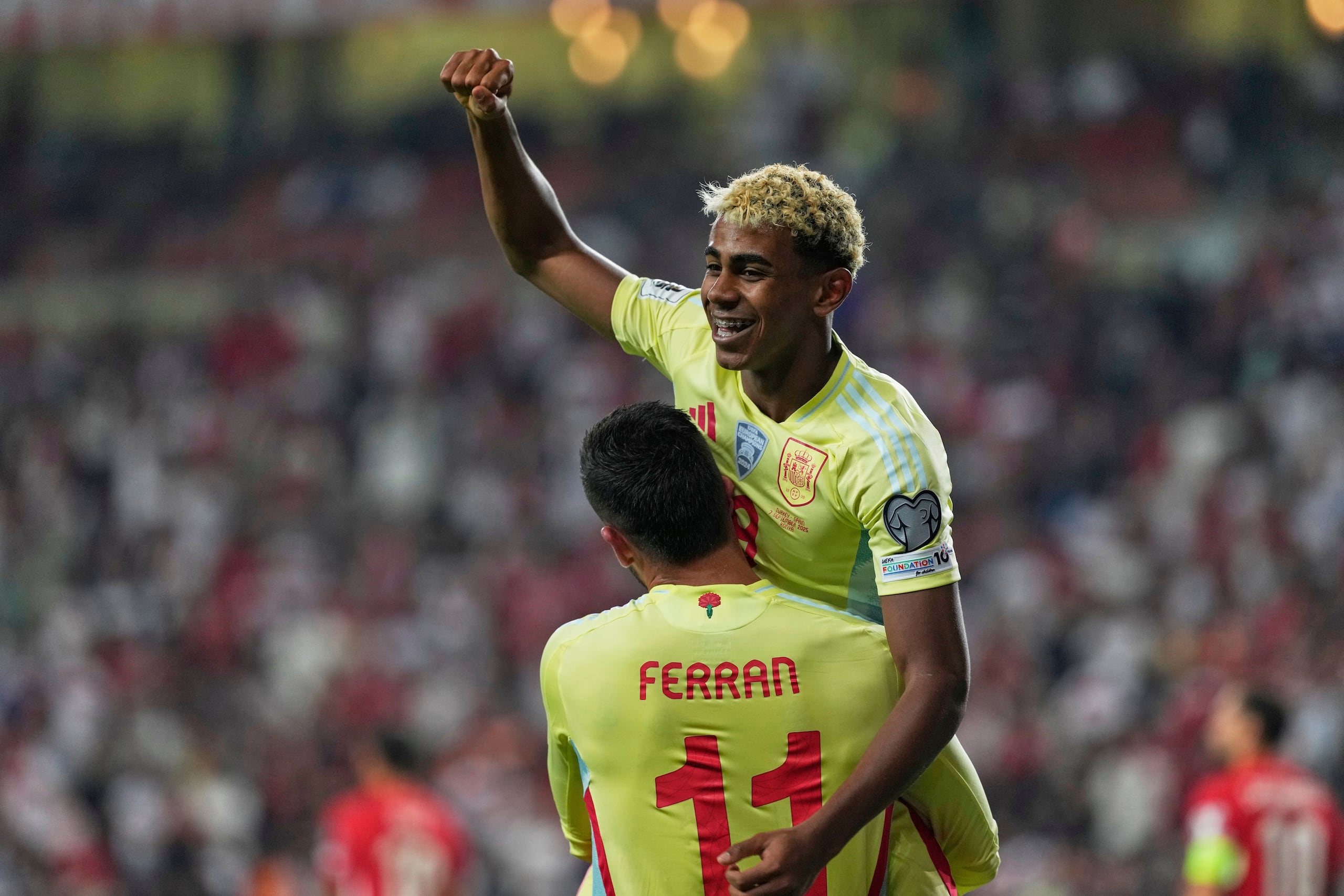 Ferran Torres, de espalda, levanta a Lamine Yamal durante un reciente partido de España en el sistema de clasificación al Mundial. (AP Photo/Khalil Hamra)