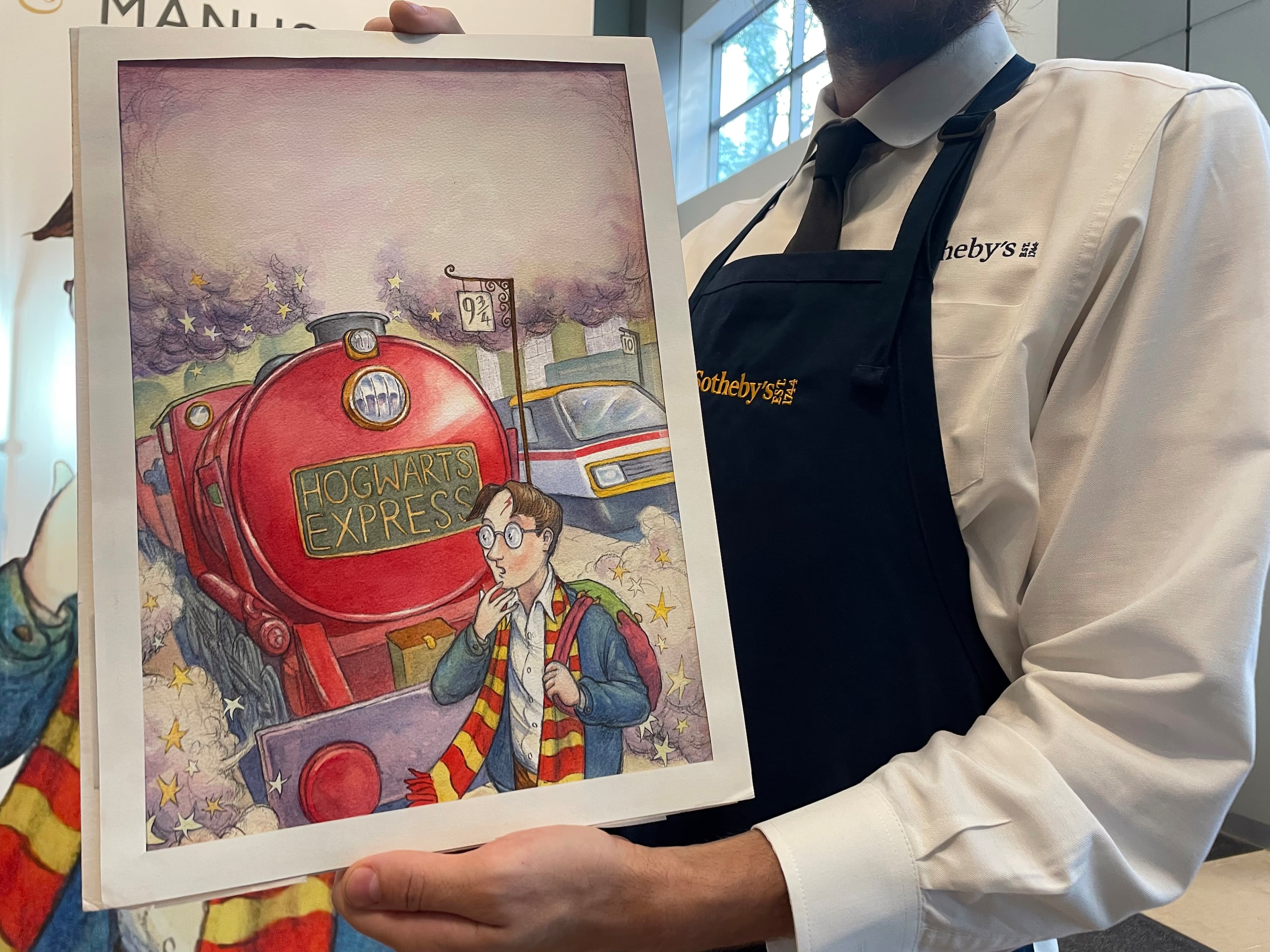 Un empleado de Sotheby's muestra la primera portada original de "Harry Potter y la piedra filosofal", elaborada en 1997 por el artista británico Thomas Taylor, este viernes en la sede de esta casa de subastas en Nueva York (EFE/Alicia Sánchez)