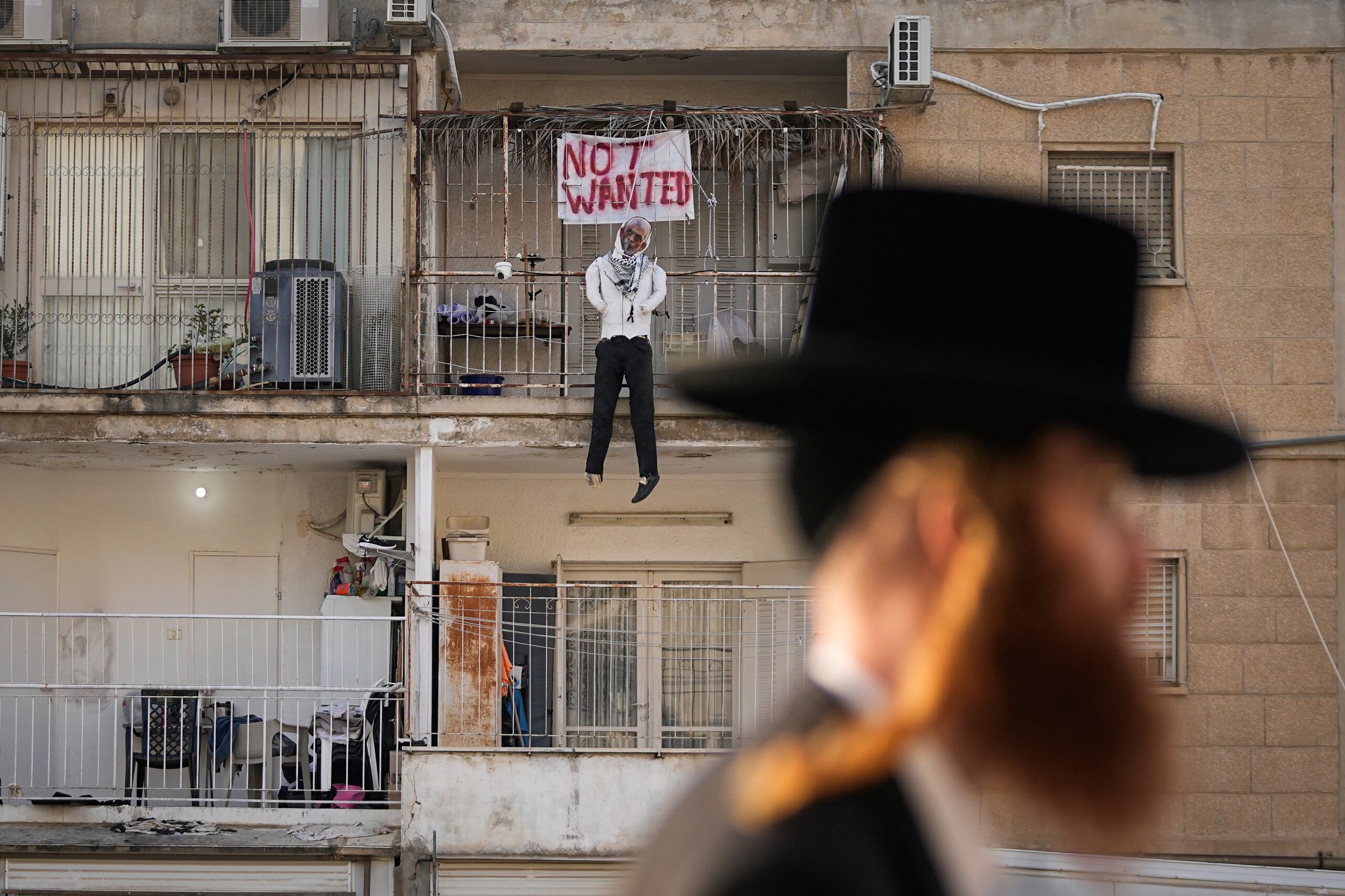 Una efigie del líder de Hamás, Yehya Sinwar, cuelga del balcón de un apartamento bajo el cartel "Indeseado", en Jerusalén el jueves 28 de marzo de 2024. (Foto AP/Ohad Zwigenberg)