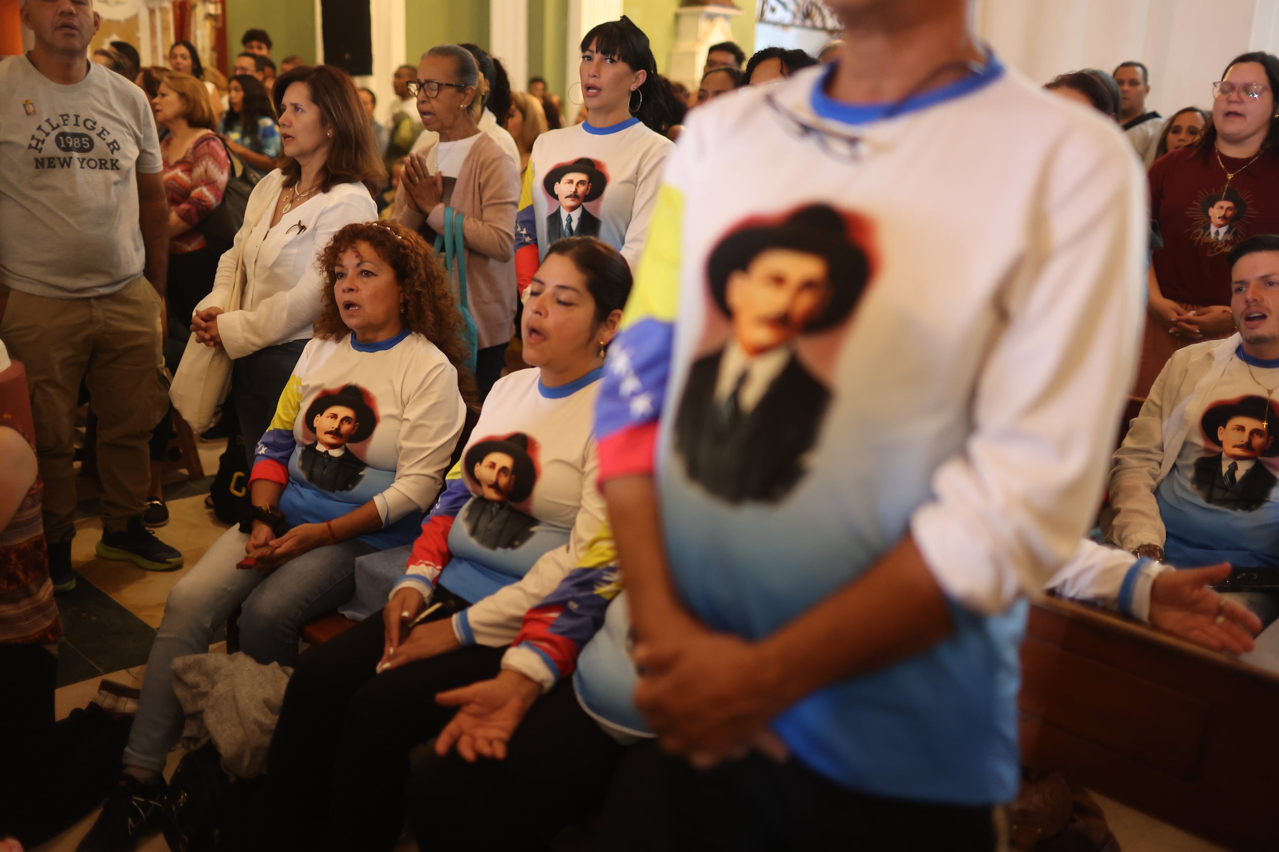 Fieles con camisetas con la imagen del médico José Gregorio Hernández rezaban en la Iglesia de la Candelaria este sábado, en Caracas (Venezuela) esperando su canonización y la de Carmen Rendiles, primeros santos del país. EFE/ Miguel Gutiérrez