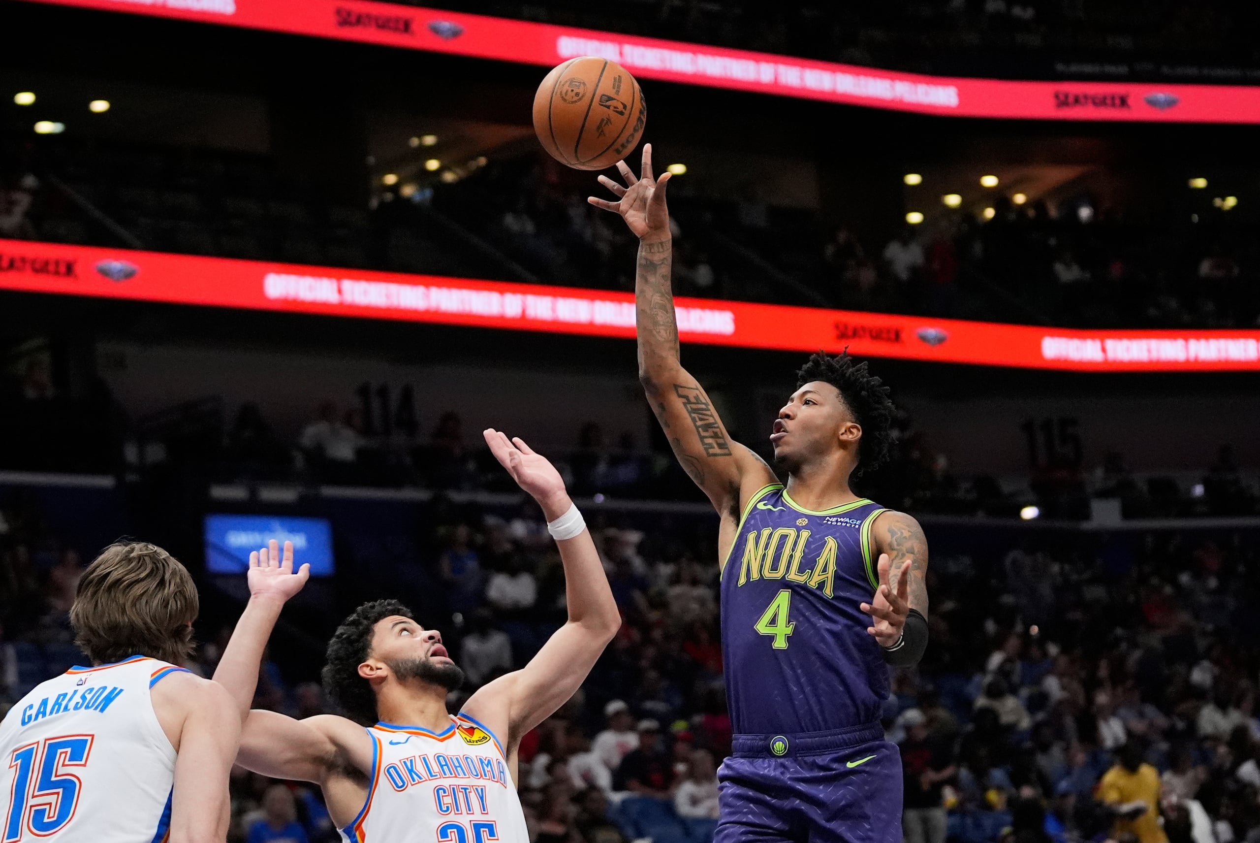 El base de los Pelicans de Nueva Orleans Elfrid Payton lanza el balón sobre Ajay Mitchell del Thunder de Oklahoma City.