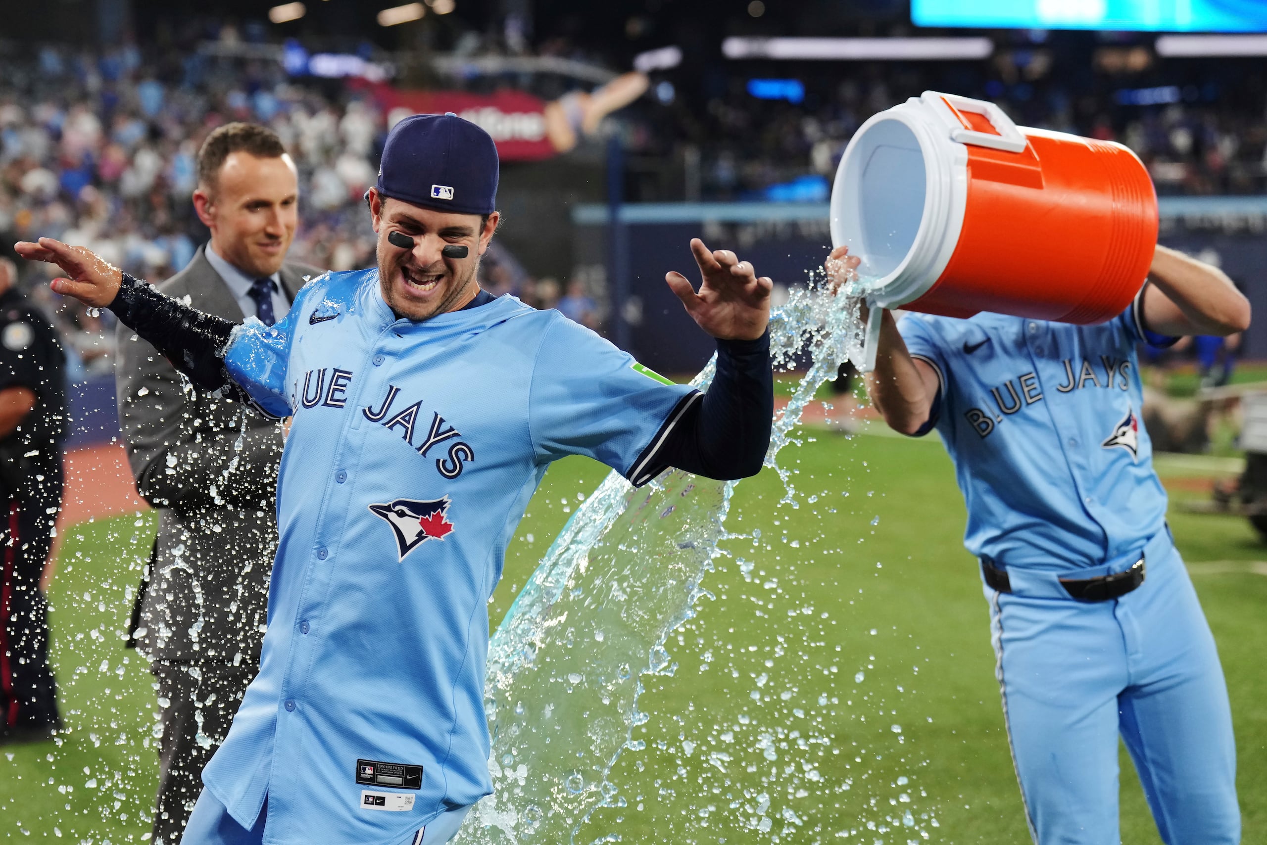 Ernie Clement de los Blue Jays de Toronto bañado por sus compañeros tras superar a los Cachorros de Chicago el martes 12 de agosto del 2025. (Nathan Denette/The Canadian Press via AP)