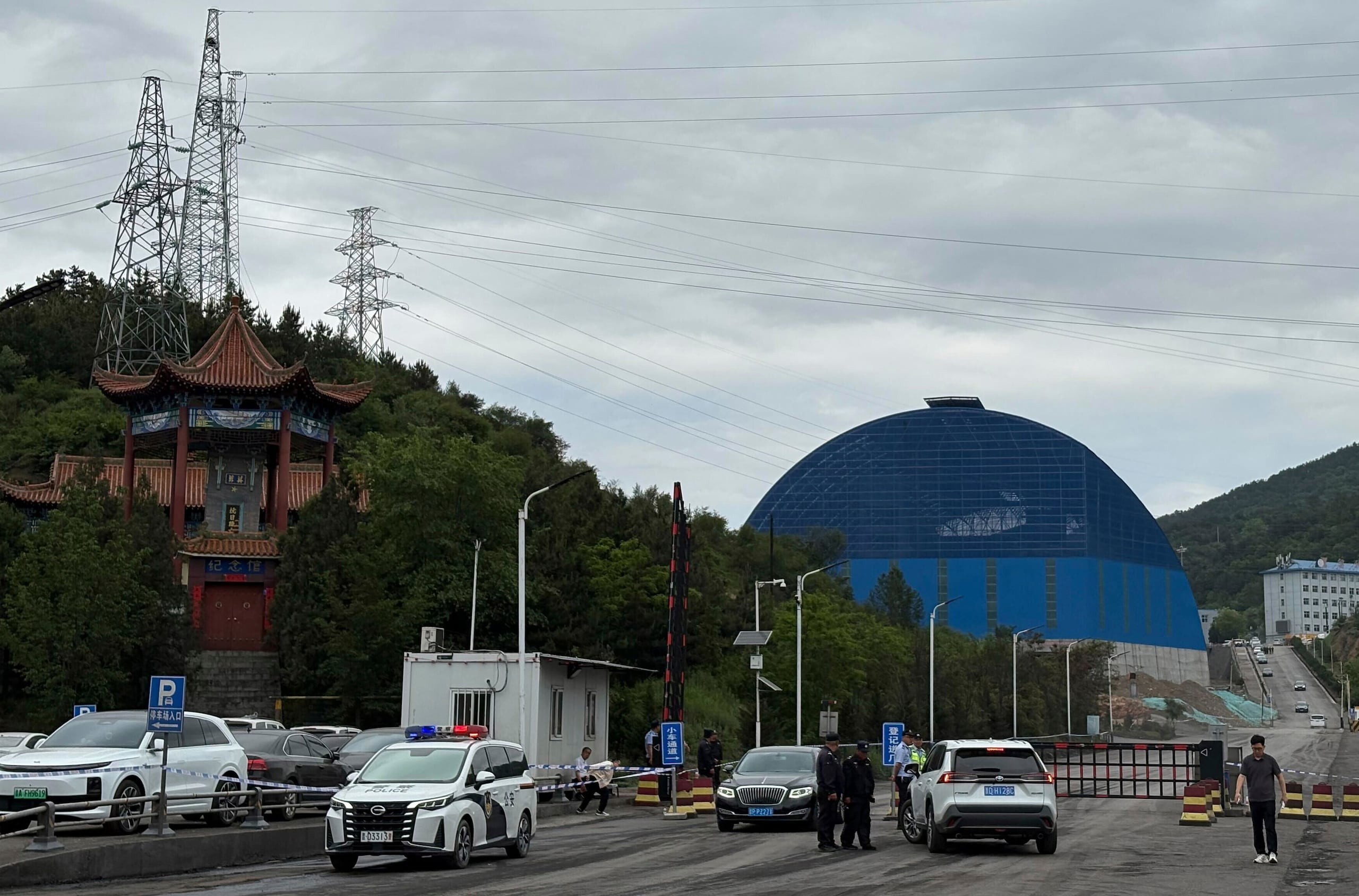 Agentes de policía en un control paran autos en el acceso al recinto de la mina de carbón Liushenyu en el condado Qinyuan en Changzhi, en el norte de la provincia china de Shanxi el domingo 24 de mayo de 2026. (AP Foto/E. Eduardo Castillo)