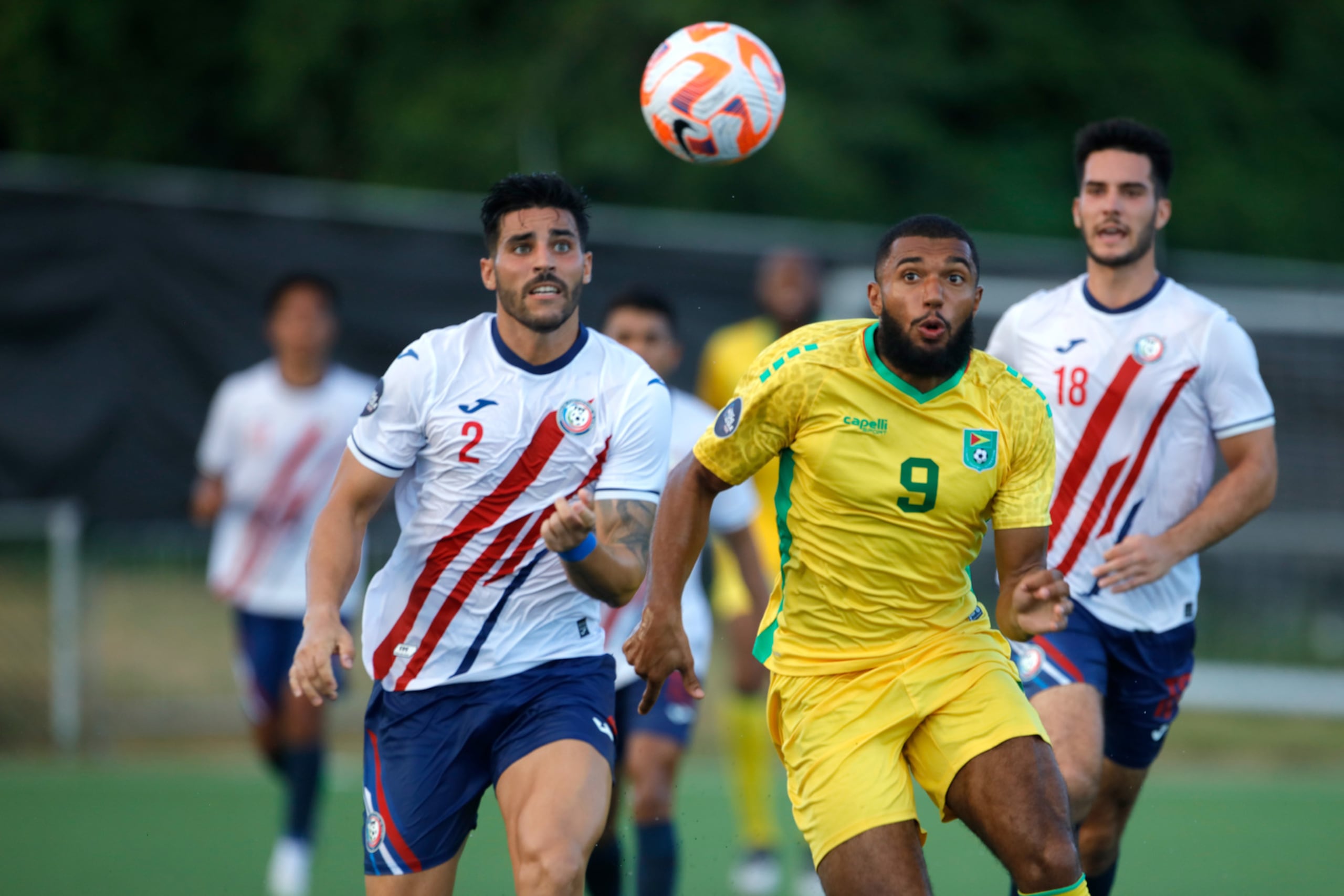 El capitán de la Selección de Puerto Rico, Nicolás Cardona, (izquierda) persigue al guyanés Deon Moore (medio) durante un partido en la segunda ventana FIFA.