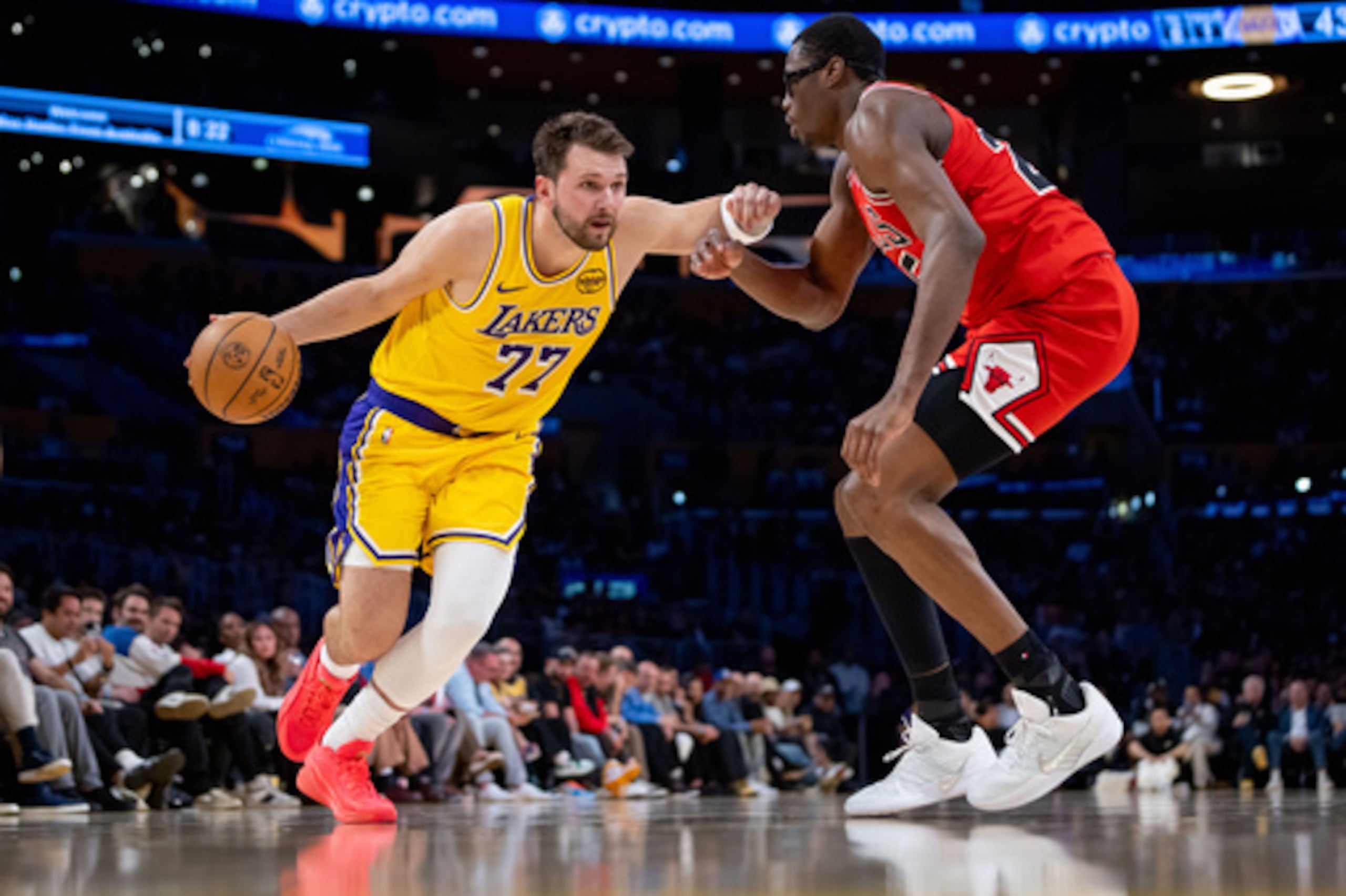El escolta de Los Ángeles Lakers Luka Doncic (77) es defendido por el alero de los Chicago Bulls Jalen Smith, derecha, durante la primera mitad de un partido de baloncesto de la NBA contra los Chicago Bulls, el jueves 12 de marzo de 2026, en Los Ángeles. (AP Photo/Ethan Swope)