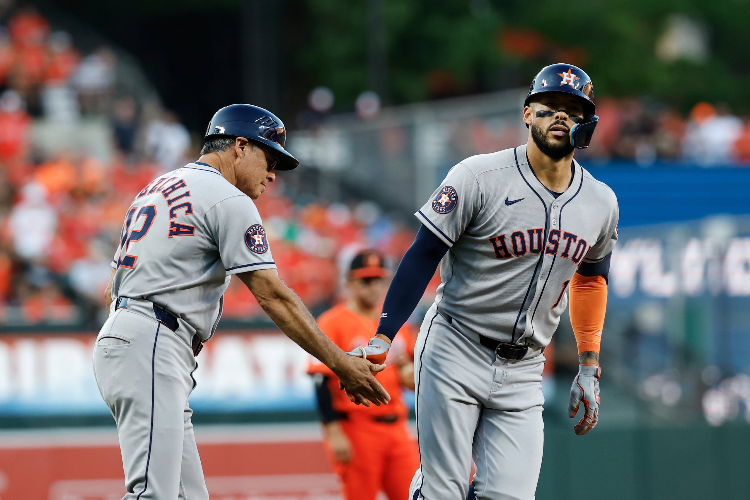 Carlos Correa, choca manos con el coach de tercera base Tony Perezchica tras su cuadrangular de dos carreras en la primera entrada.