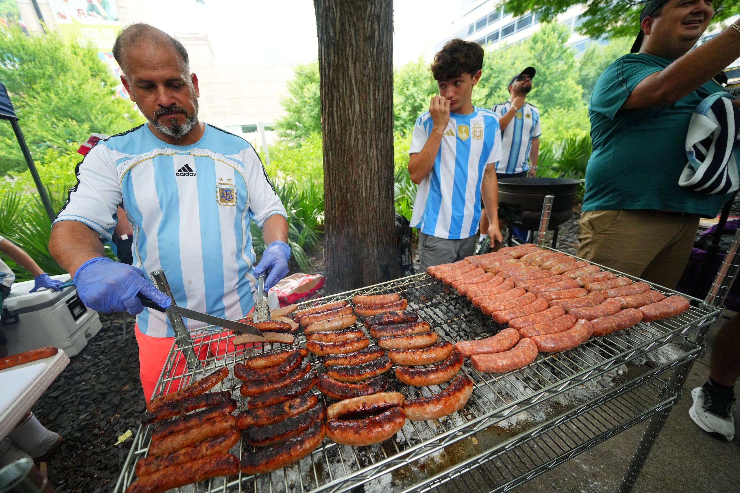 Un aficionado argentina asando embutidos previos al partido contra Austria en el Mundial, el domingo 21 de juio de 2026, en Dallas. (AP Foto/Julio Cortez)